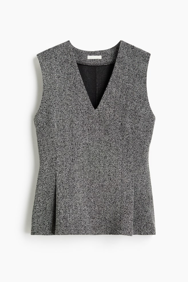 A front view of a sleeveless top is showcasing a grey and black speckled fabric with a subtle herringbone weave. It features a deep V-neckline with a visible black lining, structured shoulders, and a fitted silhouette that gently flares at the hem with front pleats. - 1