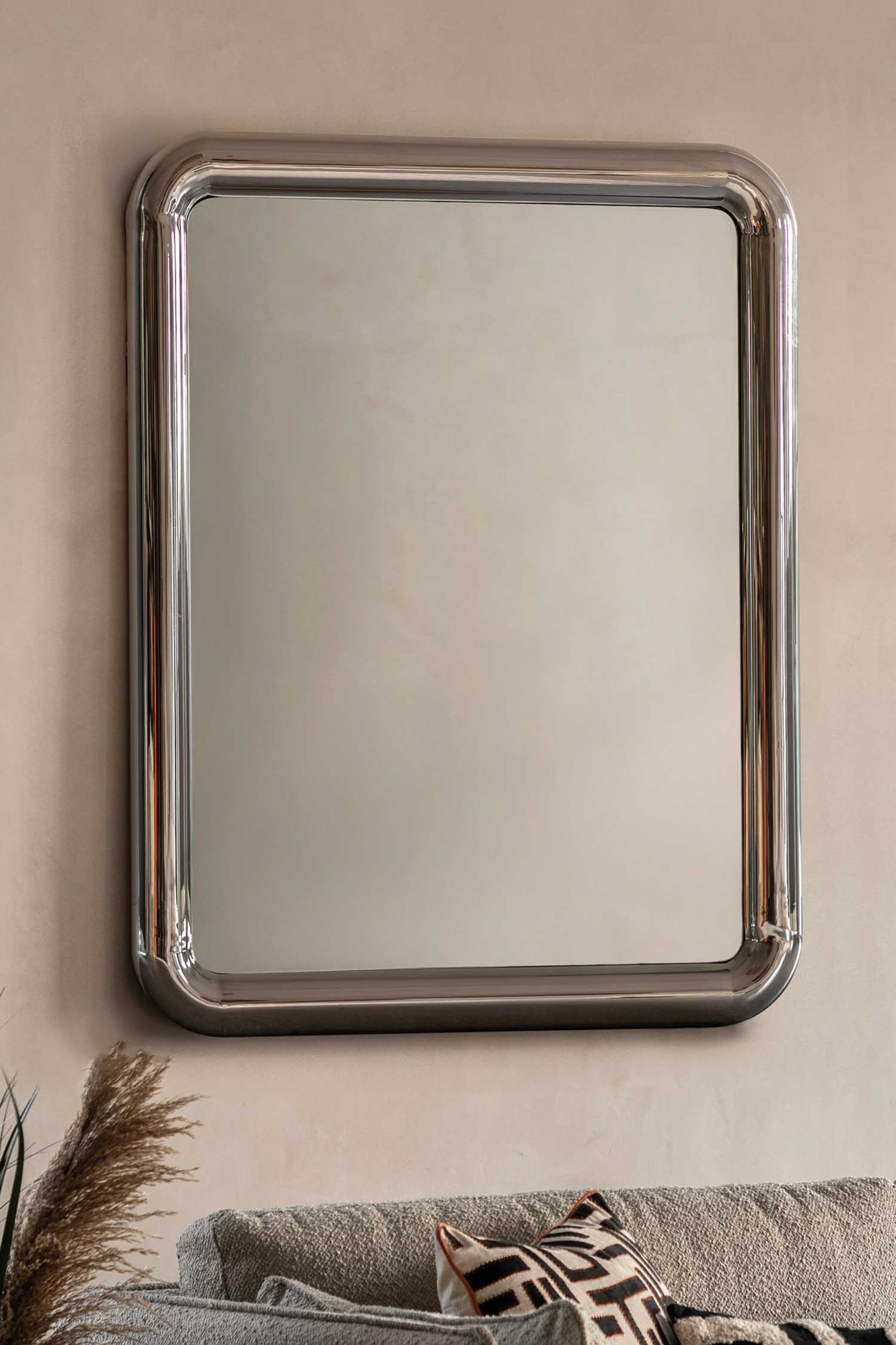 View larger image: A rectangular mirror featuring a thick, tubular, polished silver-toned metal frame with softly rounded corners.