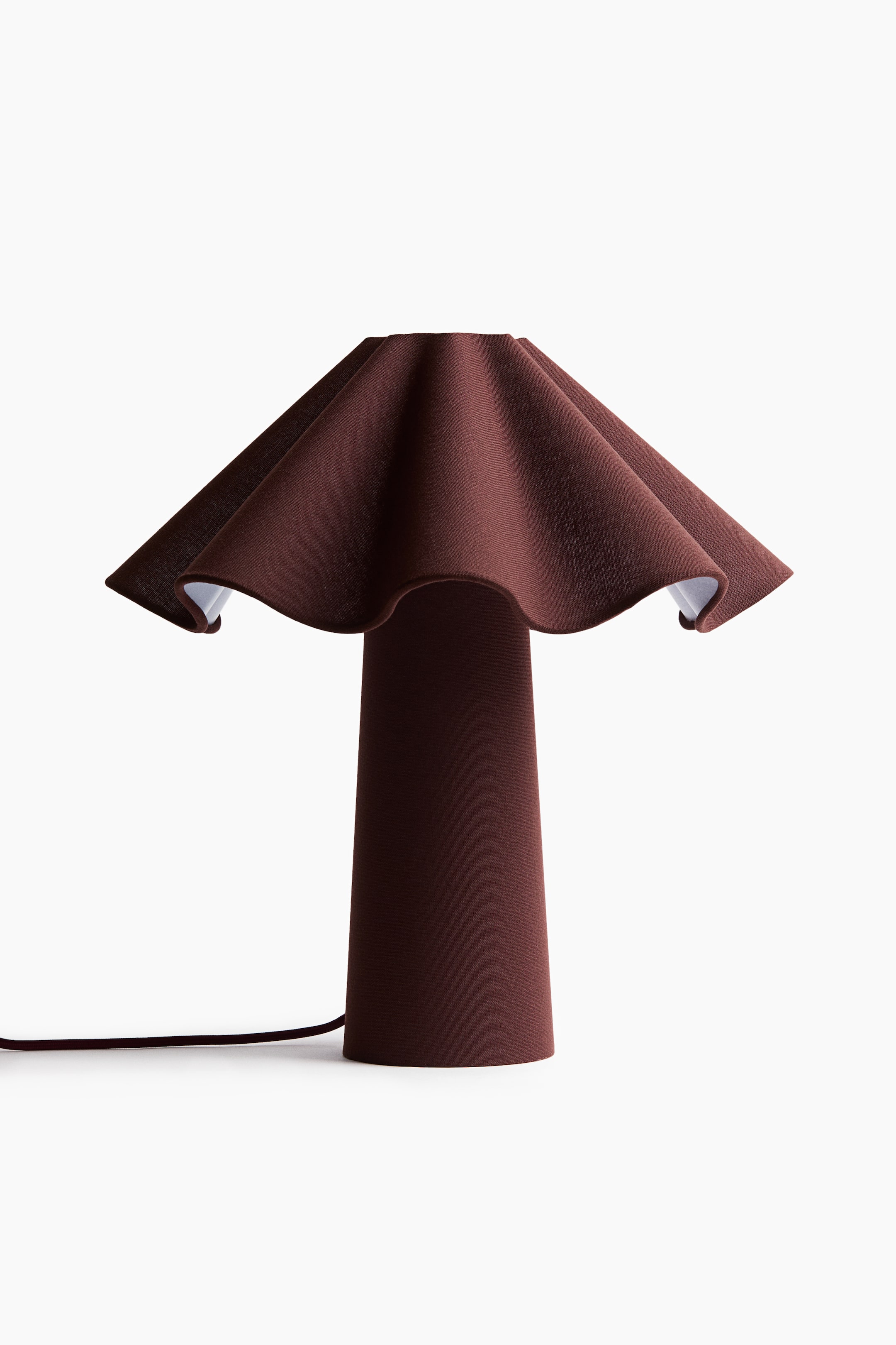 View larger image: A dark brown table lamp featuring a conical base and a wide, undulating fabric shade with a visible white interior. A dark power cord extends from the bottom of the base.