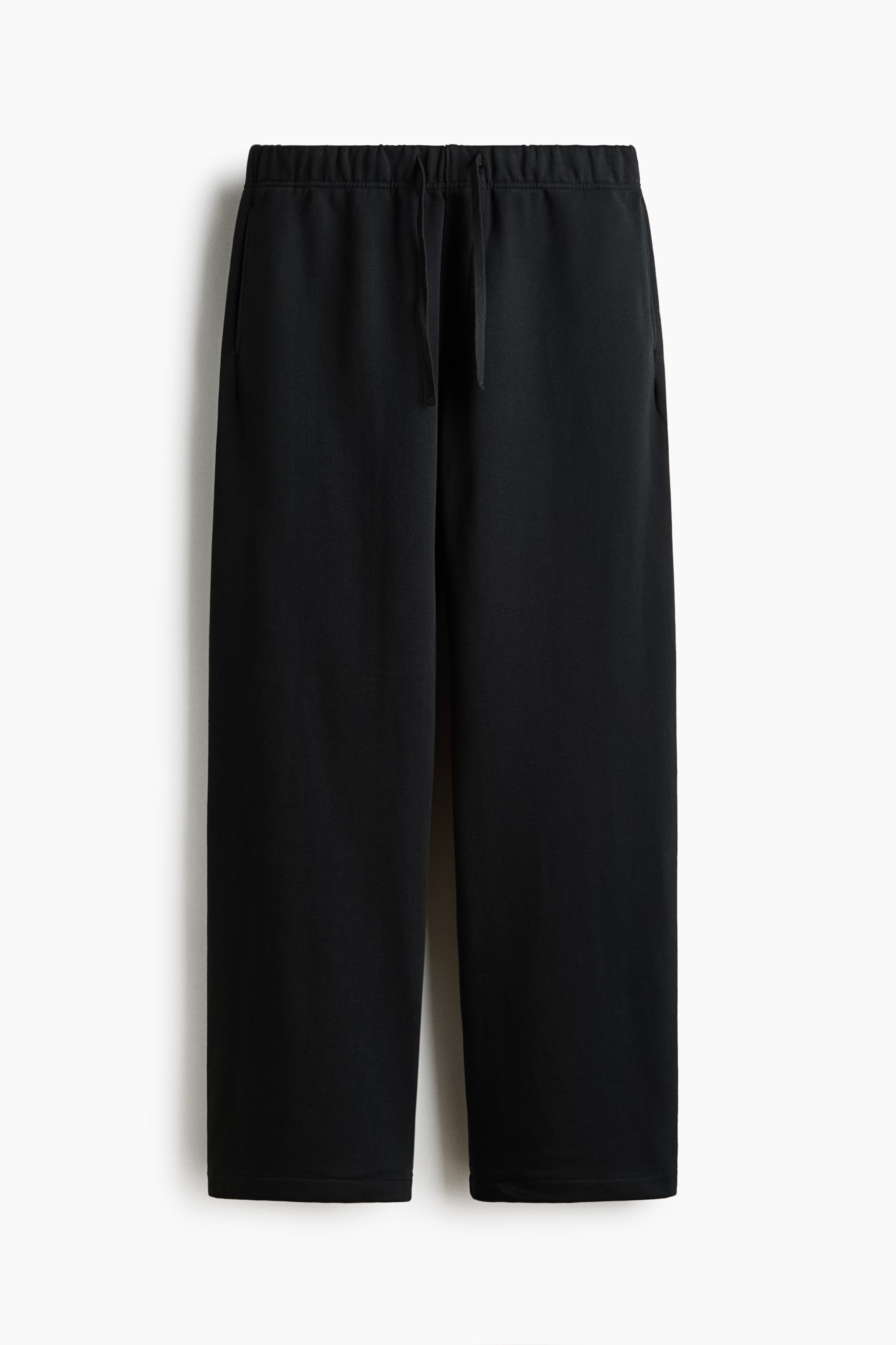 Voir une image plus grande: Pantalons noirs affichant une vue de face, avec une taille élastiquée dotée d'un cordon de serrage visible, des poches latérales et des jambes droites.