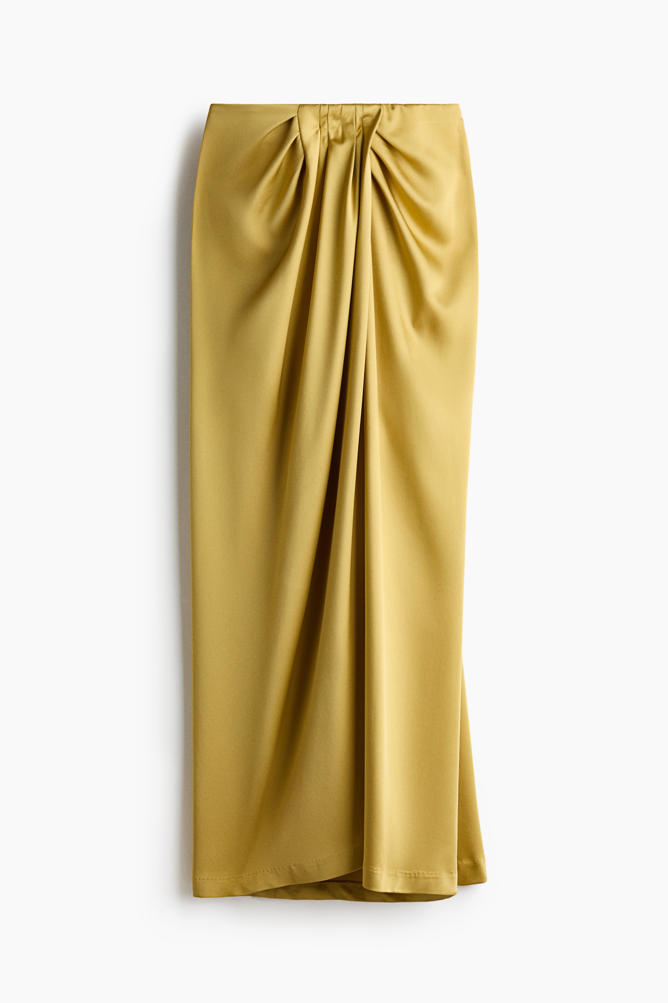 The model is wearing a draped-detail satin skirt in a mustard-yellow shade, featuring a high waist and cascading gathers that create vertical folds down the front. The maxi-length skirt is styled with a matching short-sleeved satin top in the same colour.