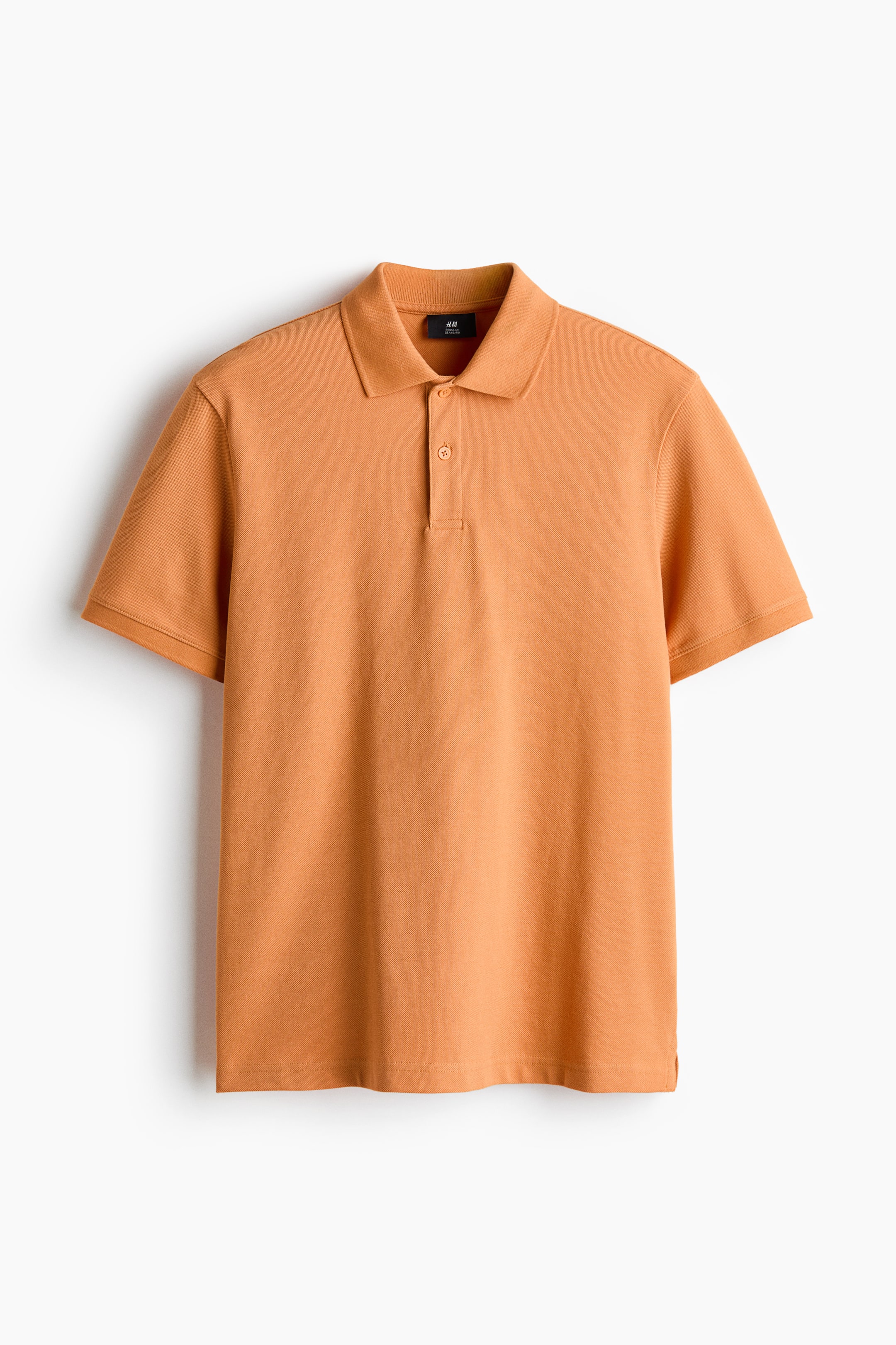 View larger image: A regular-fit orange polo shirt showcases its front, featuring a pointed collar and a two-button placket with matching buttons. It is designed with short sleeves and a straight hem that includes small side slits.