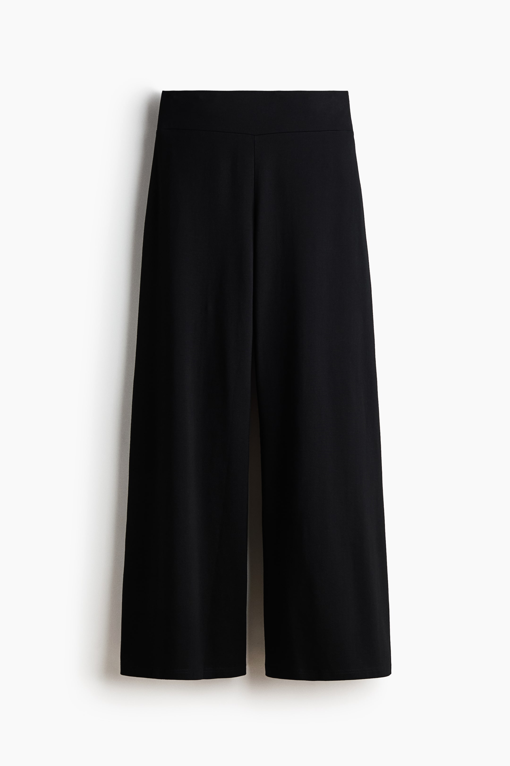 View larger image: Black trousers crafted from soft cotton jersey are showcased, featuring a broad, elastic waistband and subtly flared legs.