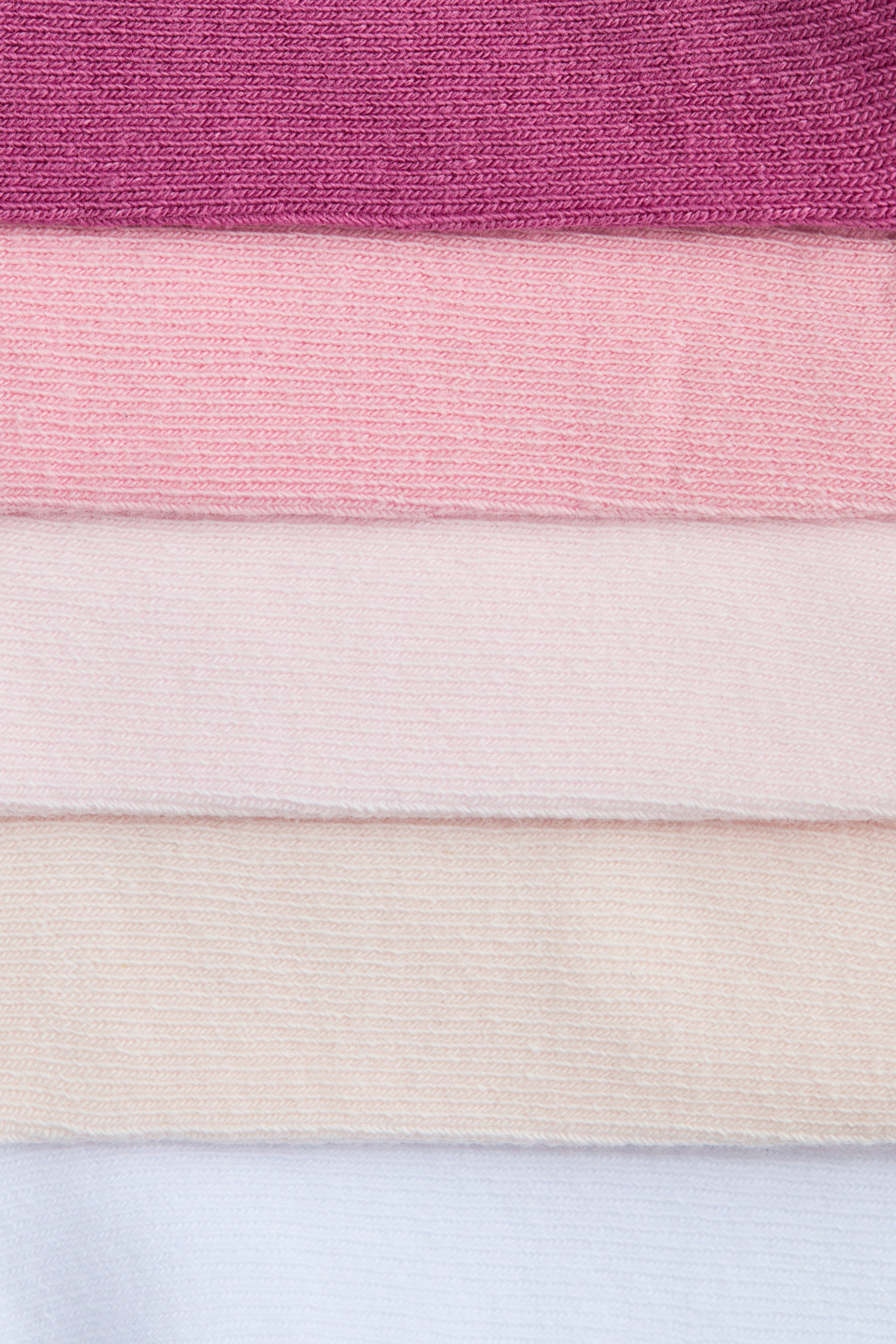 Voir une image plus grande: Les chaussettes de sport sont confectionnées dans un mélange de coton doux et finement tricoté, présentées sous forme de cinq échantillons horizontaux affichant un dégradé de couleurs allant du magenta, en passant par des roses clairs et beige, jusqu'au blanc.