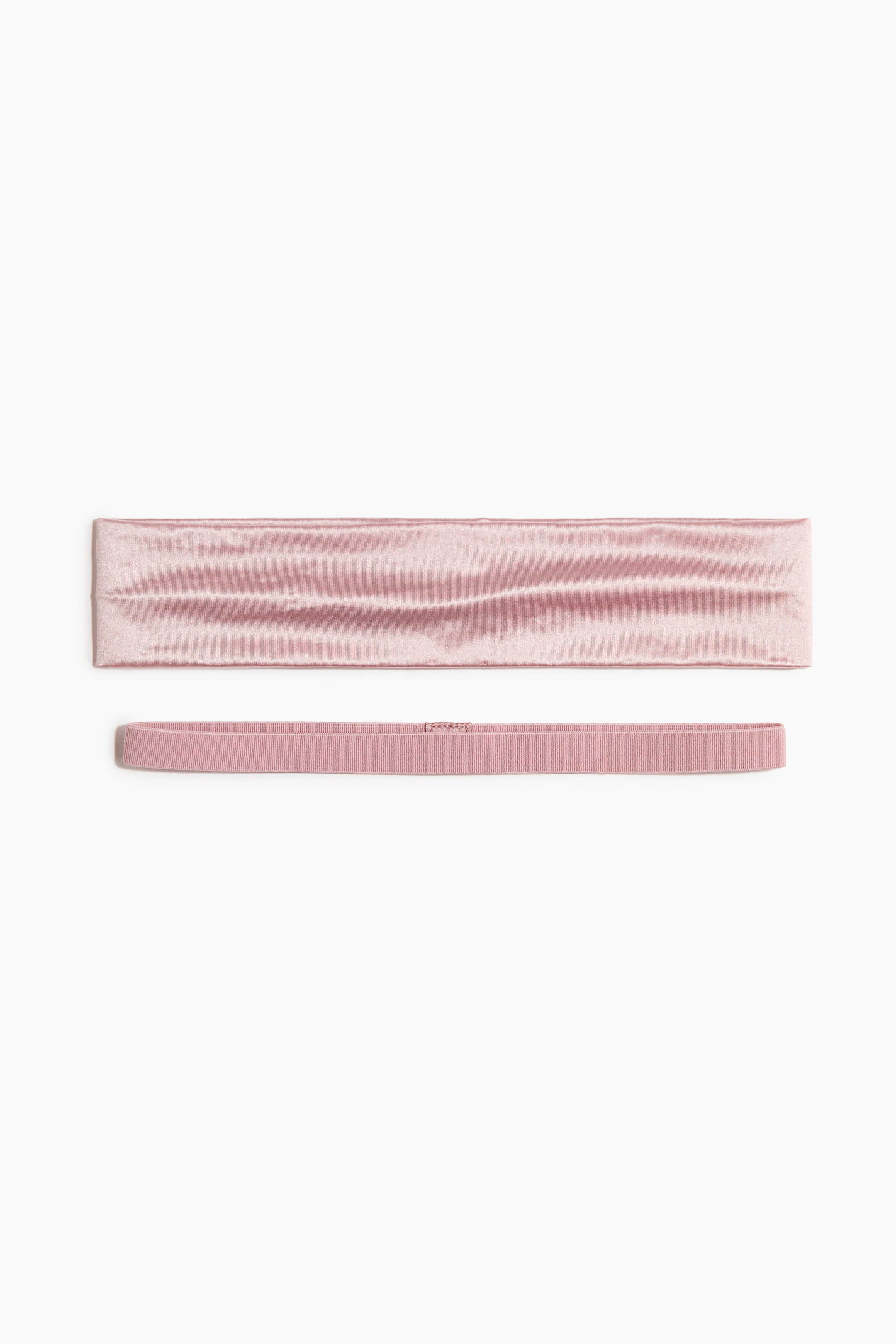 View larger image: A pair of pink headbands is displayed horizontally, featuring a wide, flat satiny band with a subtly wrinkled texture at the top, and a narrow elastic band with delicate horizontal ribbing at the bottom.