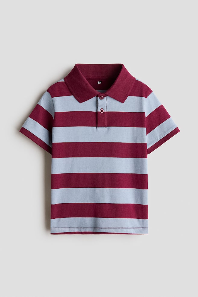 A short-sleeved polo shirt is shown from the front, featuring alternating horizontal stripes in burgundy and light blue. The shirt has a solid burgundy ribbed collar, a two-button placket with matching burgundy buttons, and short sleeves. - 1