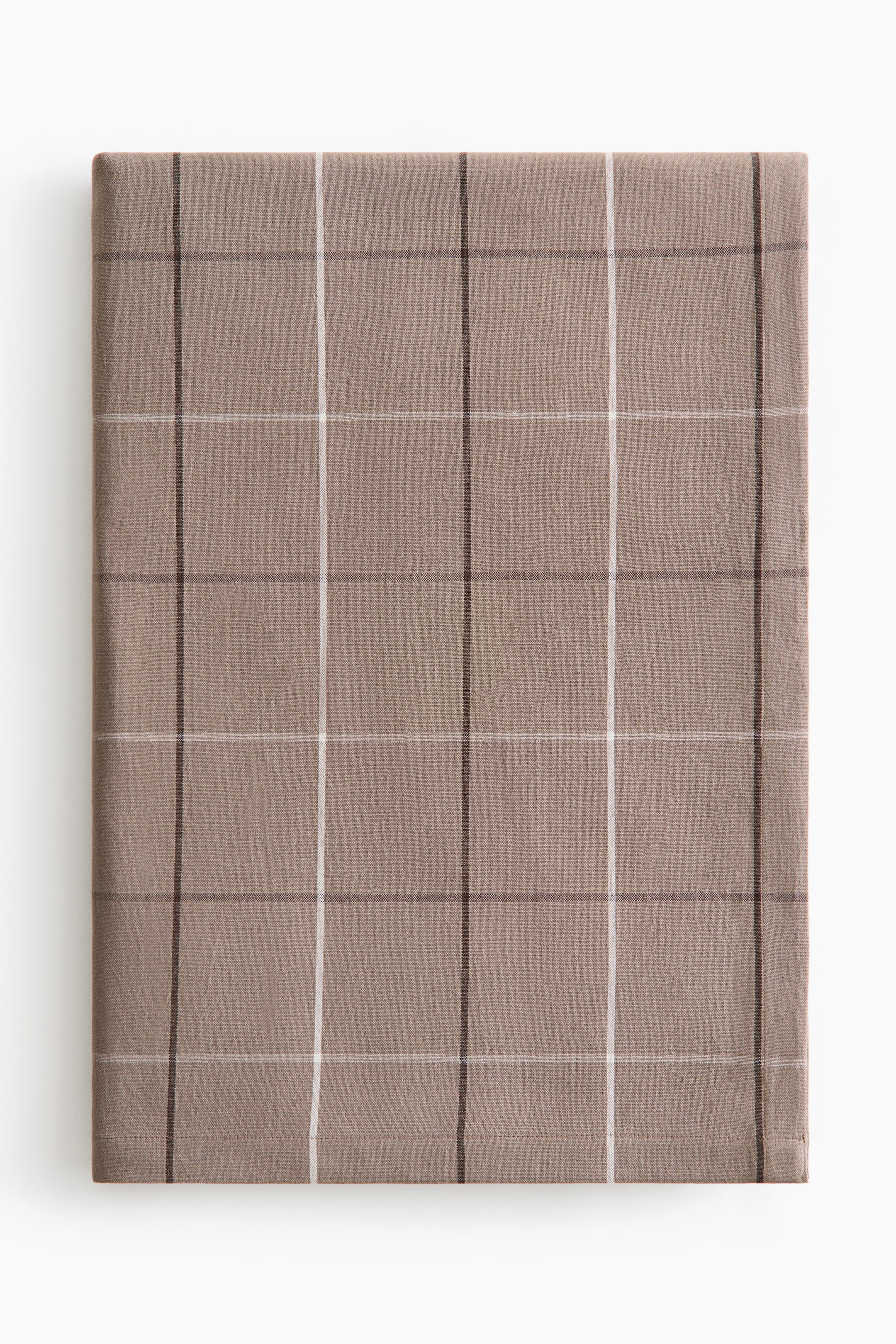 View larger image: A tablecloth, crafted from a cotton and linen blend with a thread count of 240, is spread out neatly from the front, showcasing a yarn-dyed grid pattern with thin dark brown and white lines on a light brown backdrop. It is completed with a 2.5 cm folded hem along its visible edges.
