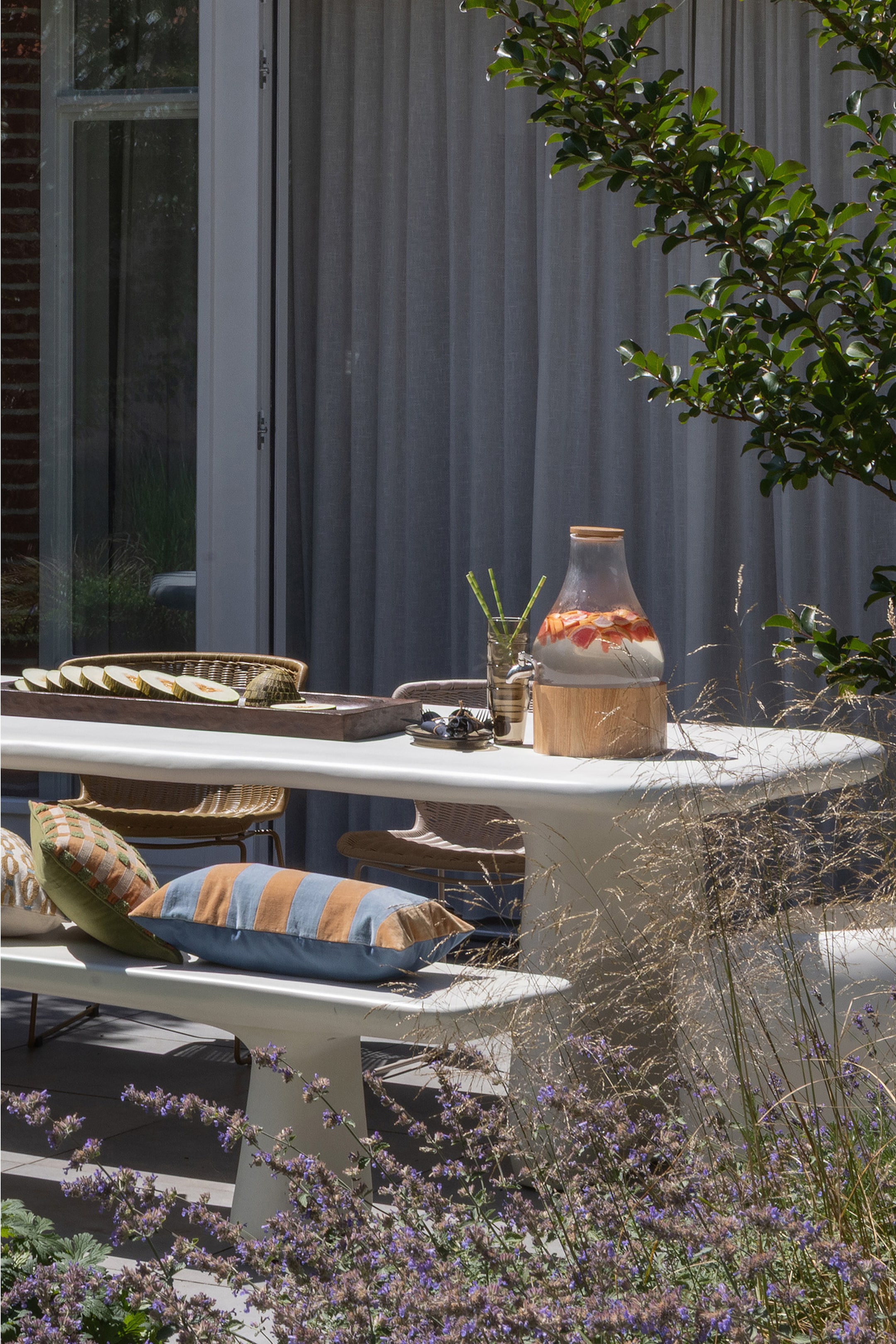 Agrandir l'image: Un distributeur de boissons en verre transparent repose sur une base en bois clair, avec un couvercle en bois assorti et rempli d'eau et de tranches de fruits.