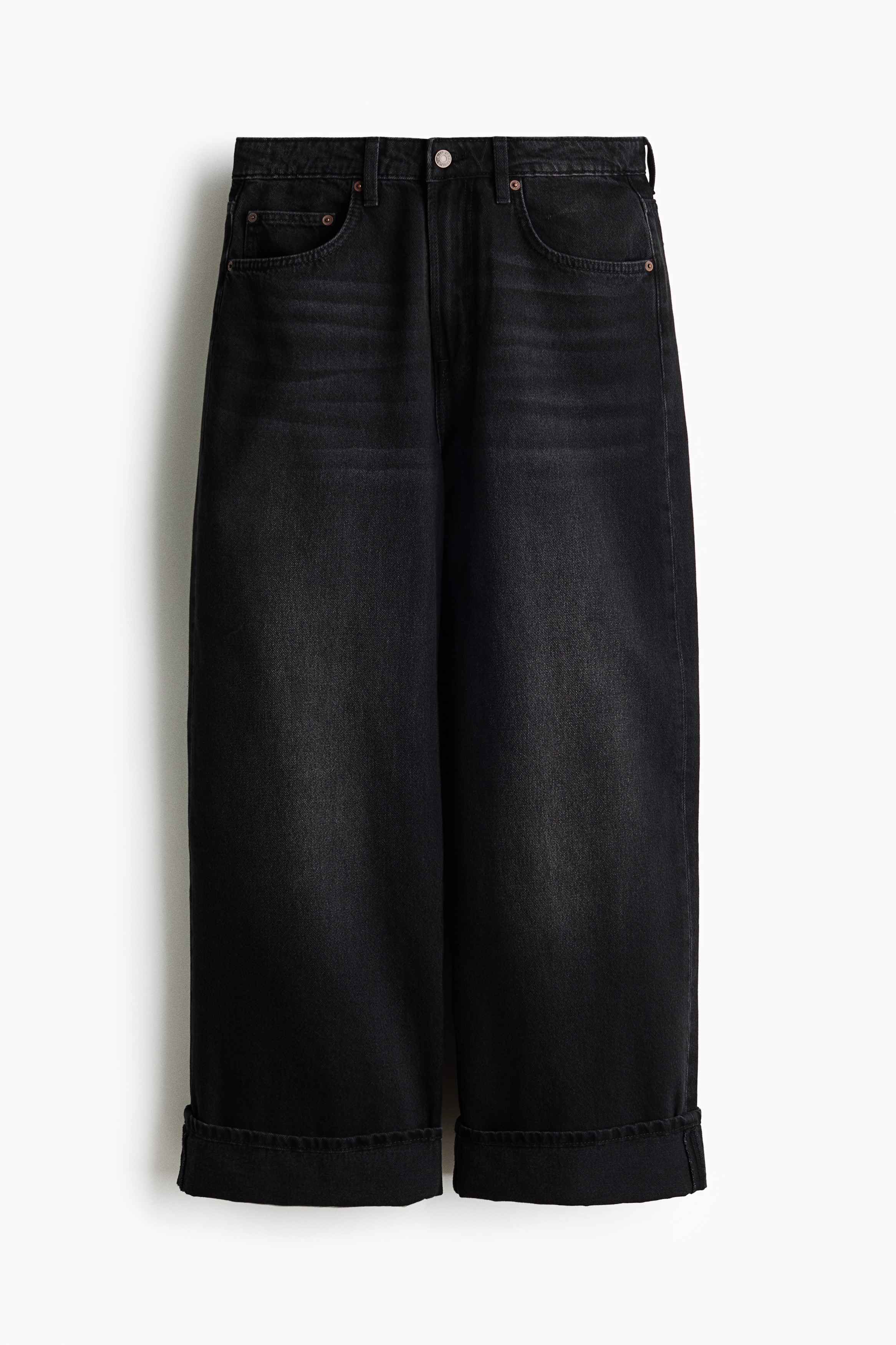Le mannequin porte un jean en denim gris foncé à coupe droite, avec une coupe décontractée qui descend jusquâaux pieds. Le jean est associé à une chemise blanche oversize, superposée sous une veste jaune texturée courte, et complété par des chaussures noires à bout pointu.