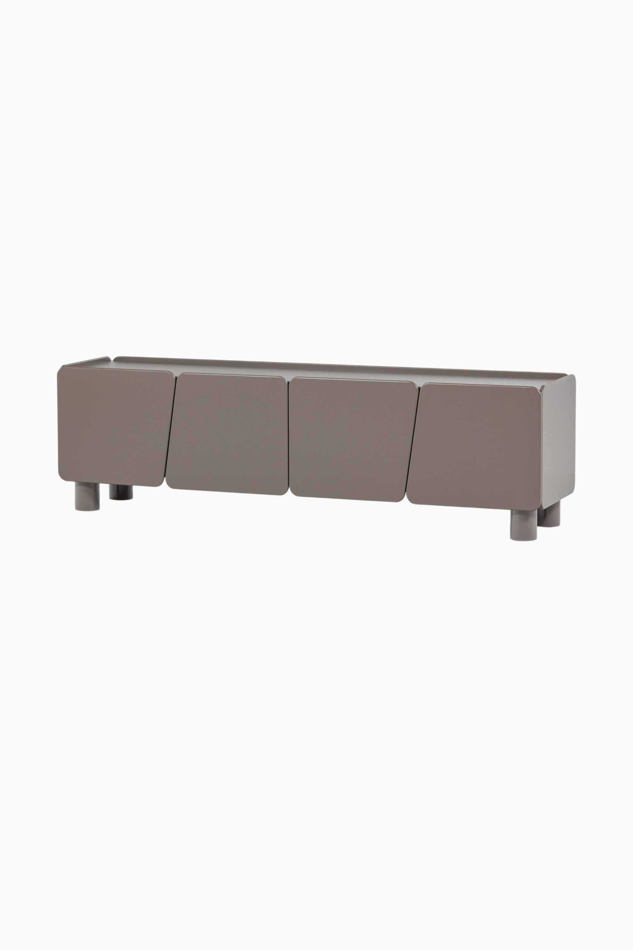 Agrandir l'image: Un meuble bas de couleur taupe présente quatre panneaux frontaux rectangulaires, séparés par des coutures verticales inclinées. Le meuble repose sur deux pieds cylindriques à chaque extrémité et affiche une finition lisse et mate, vue sous un angle légèrement surélevé à l'avant-droit.
