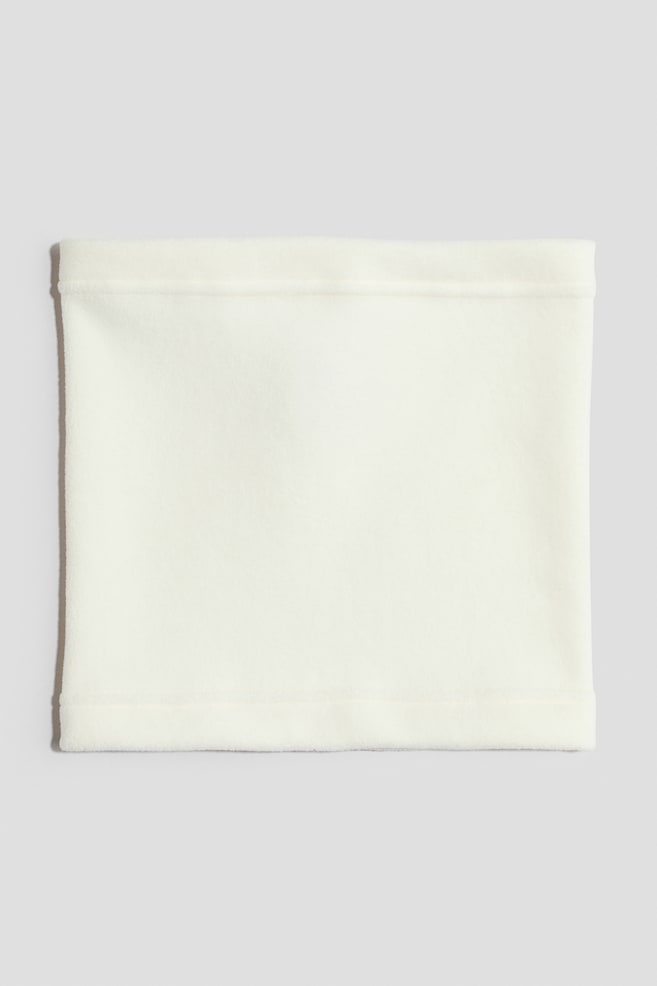 Una sciarpa a tubo in tessuto pile color bianco sporco Ã¨ distesa in piano, presentando una vista frontale della sua forma rettangolare e della sua texture morbida. La sciarpa presenta orli rifiniti e cuciti alle aperture superiore e inferiore. - 1