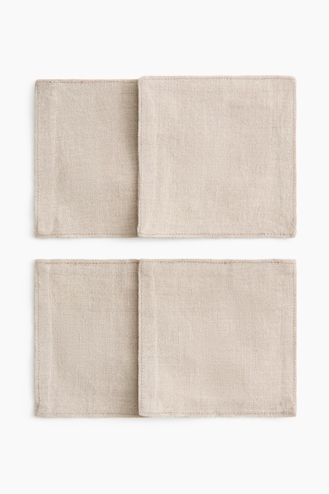 Vier rechteckige Tischsets sind in zwei Paaren angeordnet und zeigen eine natürliche beige Farbe sowie eine sichtbare gewebte Struktur. Jedes Tischset verfügt über einen einfachen, sauber genähten Rand. - 1