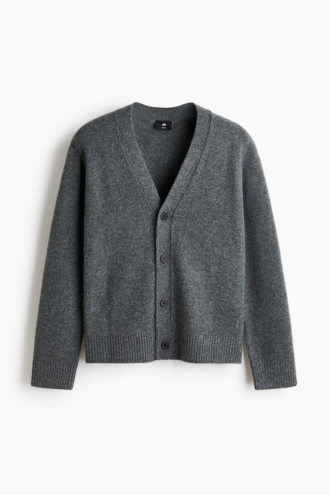 Een donkergrijze gemêleerde cardigan toont zijn voorkant, met een V-hals en vijf donkere, ronde knopen. Het is ontworpen met geribbelde manchetten en een geribbelde zoom. - 1