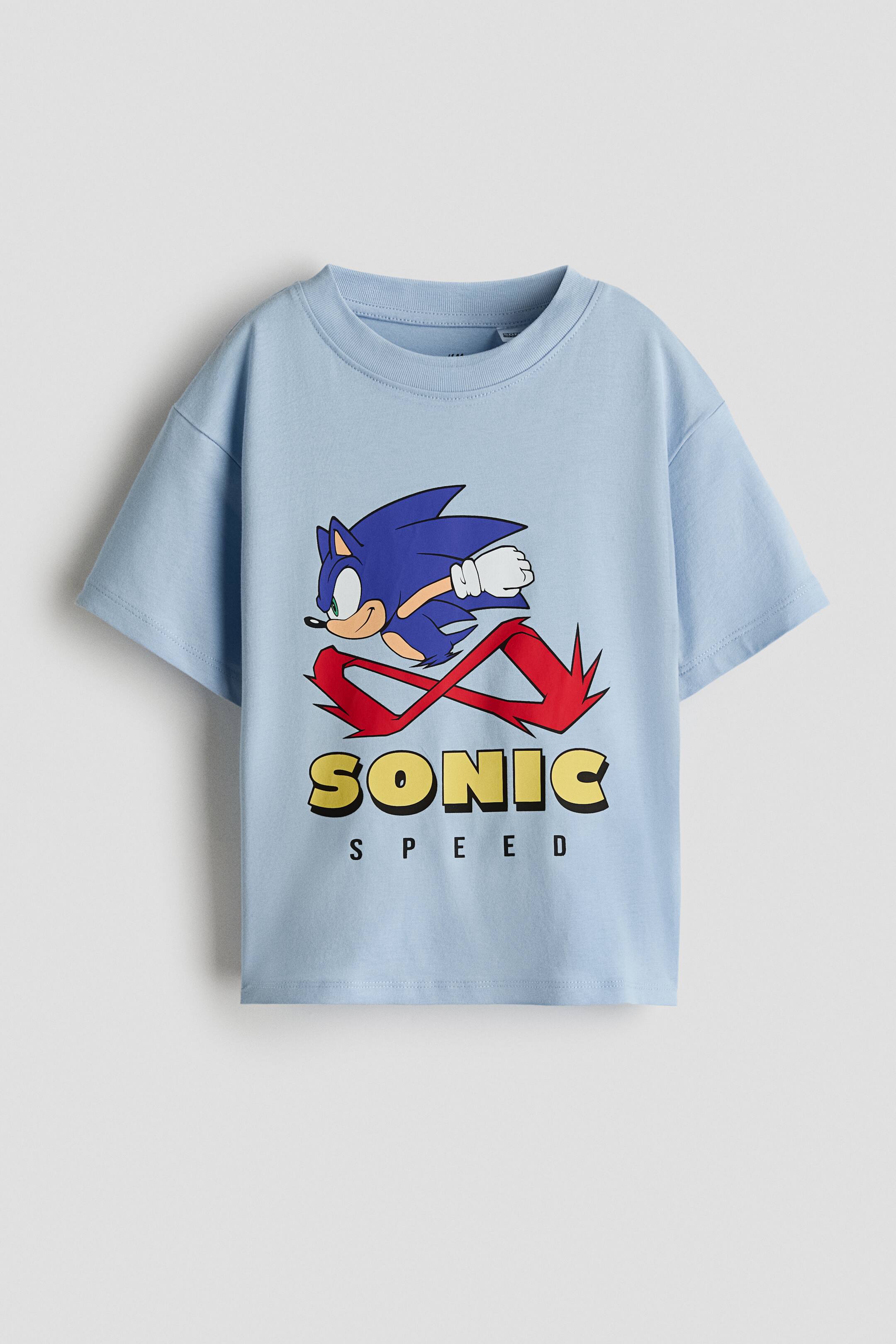 View larger image: A light blue cotton jersey T-shirt, shown from the front, features a rib-trimmed round neckline, gently dropped shoulders, and a printed graphic of Sonic the Hedgehog running above the words "SONIC SPEED".