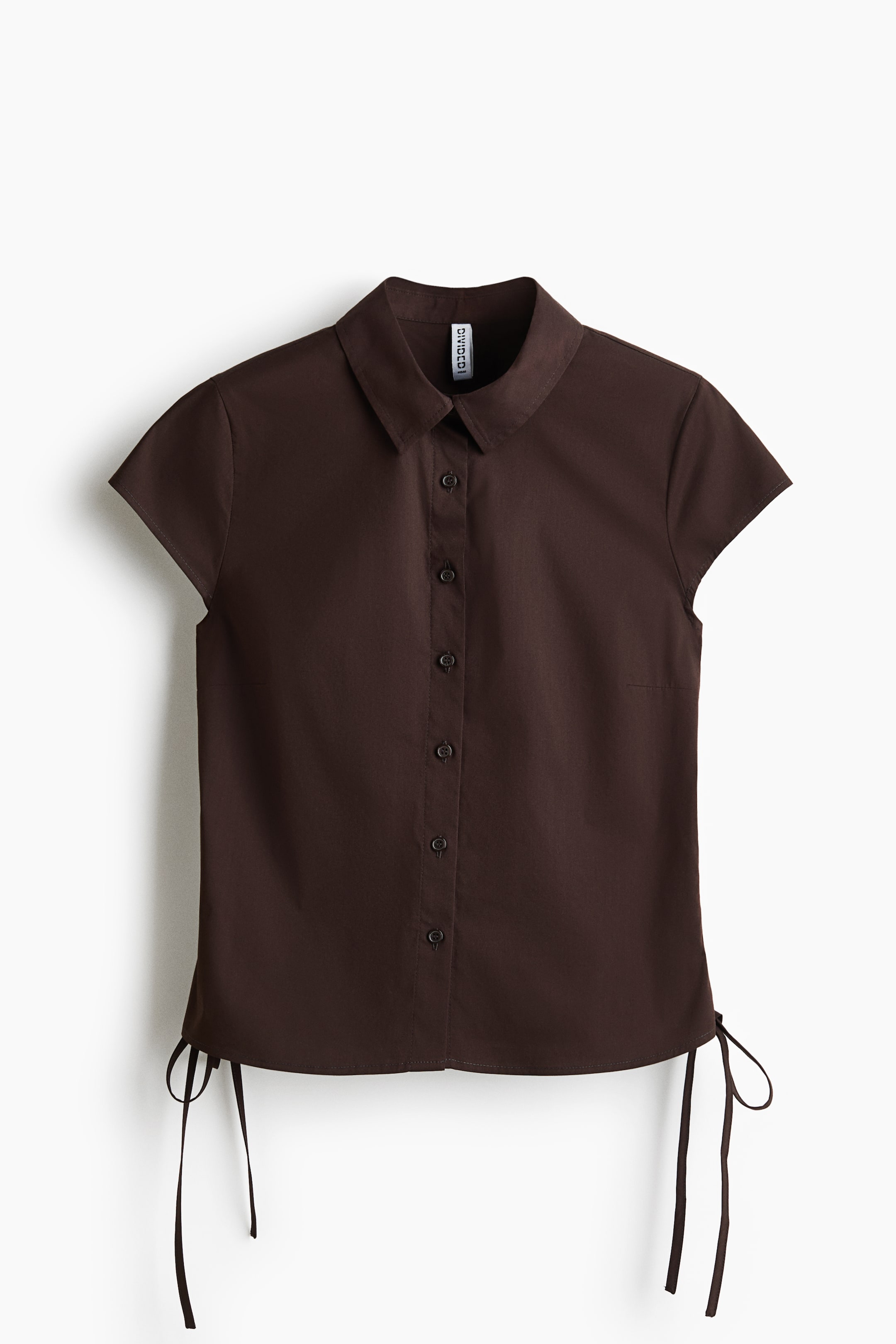 View larger image: "A dark brown short-sleeved shirt showcases its front, highlighting a pointed collar, a full button-front placket with matching buttons, and short cap sleeves. The bottom hem is adorned with two ties on each side."