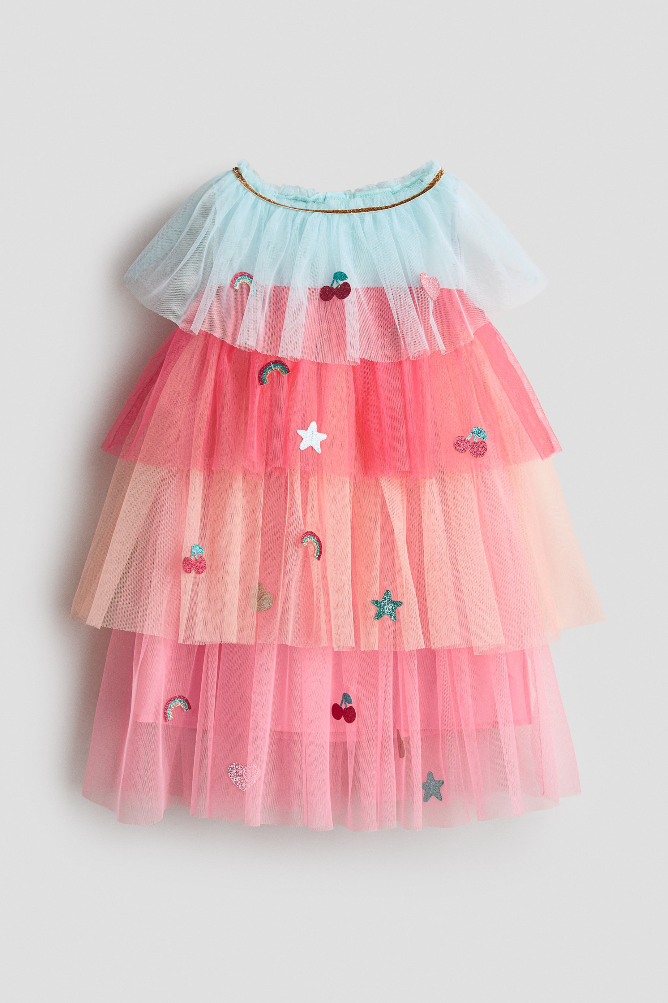 Ampliar la imagen: Se presenta un vestido a capas por el FRENTE, con capas de tul rosa y durazno. Un sobrefalda de tul azul claro forma el corpiño superior, acentuado con un ribete dorado en el escote, mientras que apliques brillantes de cerezas, arcoíris, estrellas y corazones están dispersos a lo largo de las capas de tul.