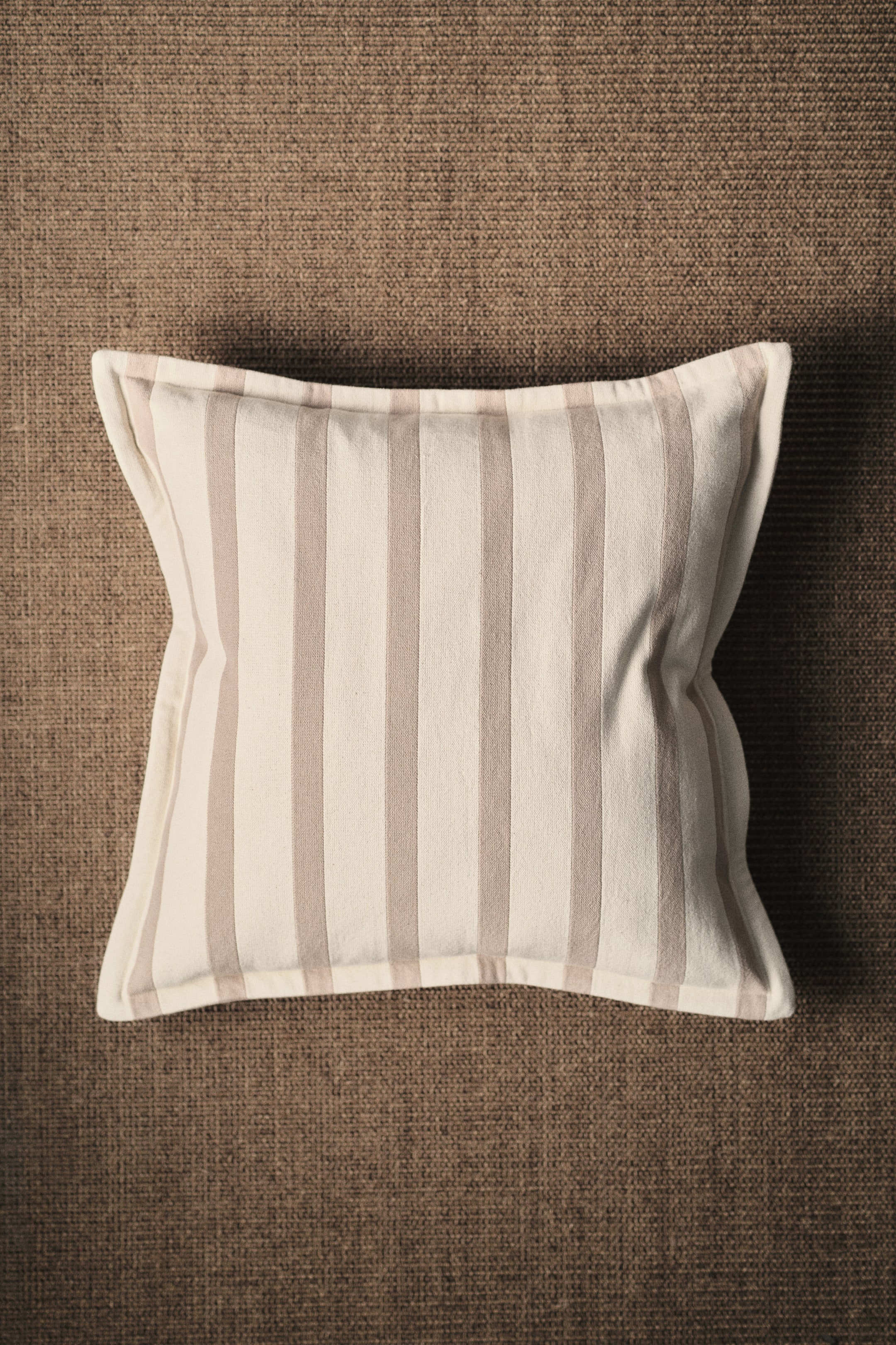 View larger image: A cushion cover in cotton canvas showcases its front, featuring a pattern of alternating light beige and taupe vertical stripes.