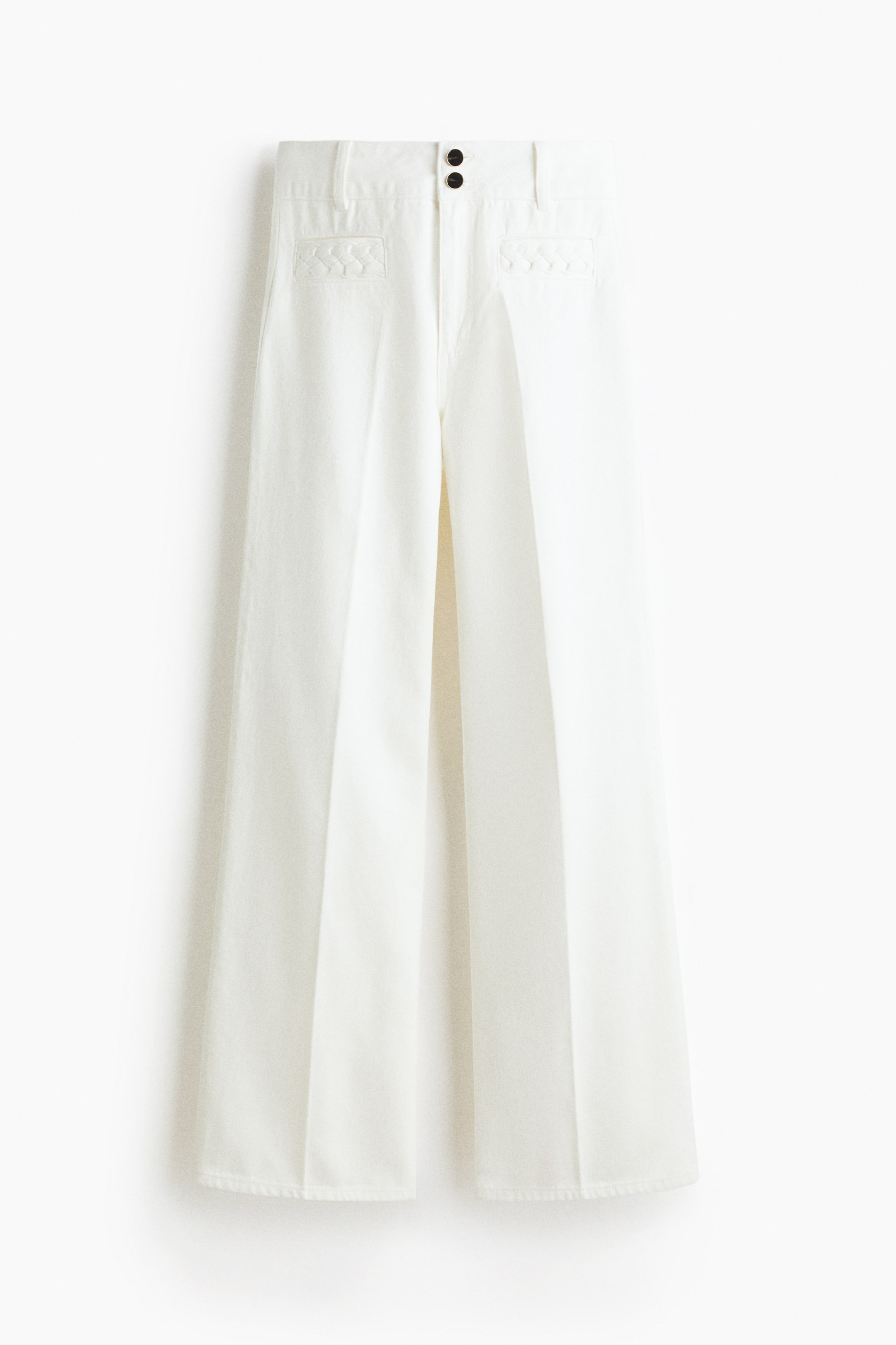 Voir une image plus grande: VUE DE FACE. Un pantalon à jambes larges de couleur blanche se distingue par une taille haute avec une fermeture éclair et deux boutons foncés. Les poches avant passepoilées présentent une garniture tressée, et des plis descendent devant les jambes larges.