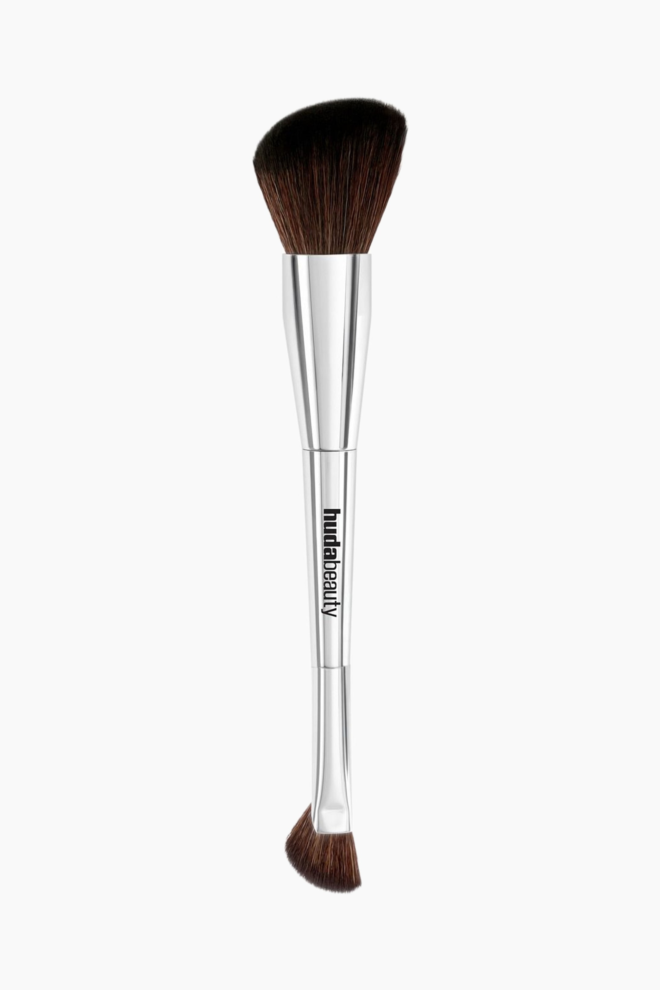 Näytä suurempi kuva: Tämä kaksipäinen Bronze & Contour Brush seisoo pystyasennossa ja esittelee metallinhohtoista hopeista vartta, johon on painettu mustalla "hudabeauty"-brändin nimi. Harjassa on toisessa päässä suuri, viistottu harjaspää tummanruskeilla harjaksilla ja vastakkaisessa päässä pienempi, viistottu harjaspää samanvärisillä harjaksilla.