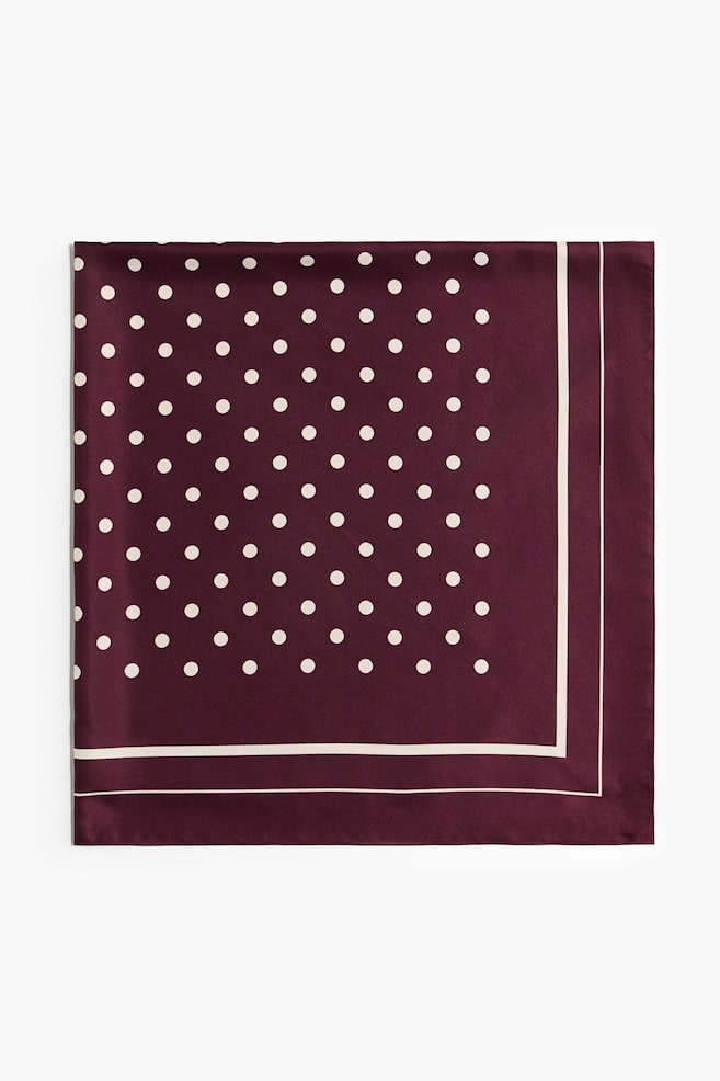 A square scarf in a soft weave is lying flat, presenting its front design in a deep burgundy color. It is showcasing a printed pattern of white polka dots in the center, bordered by a solid burgundy frame with two thin white stripes. - 1