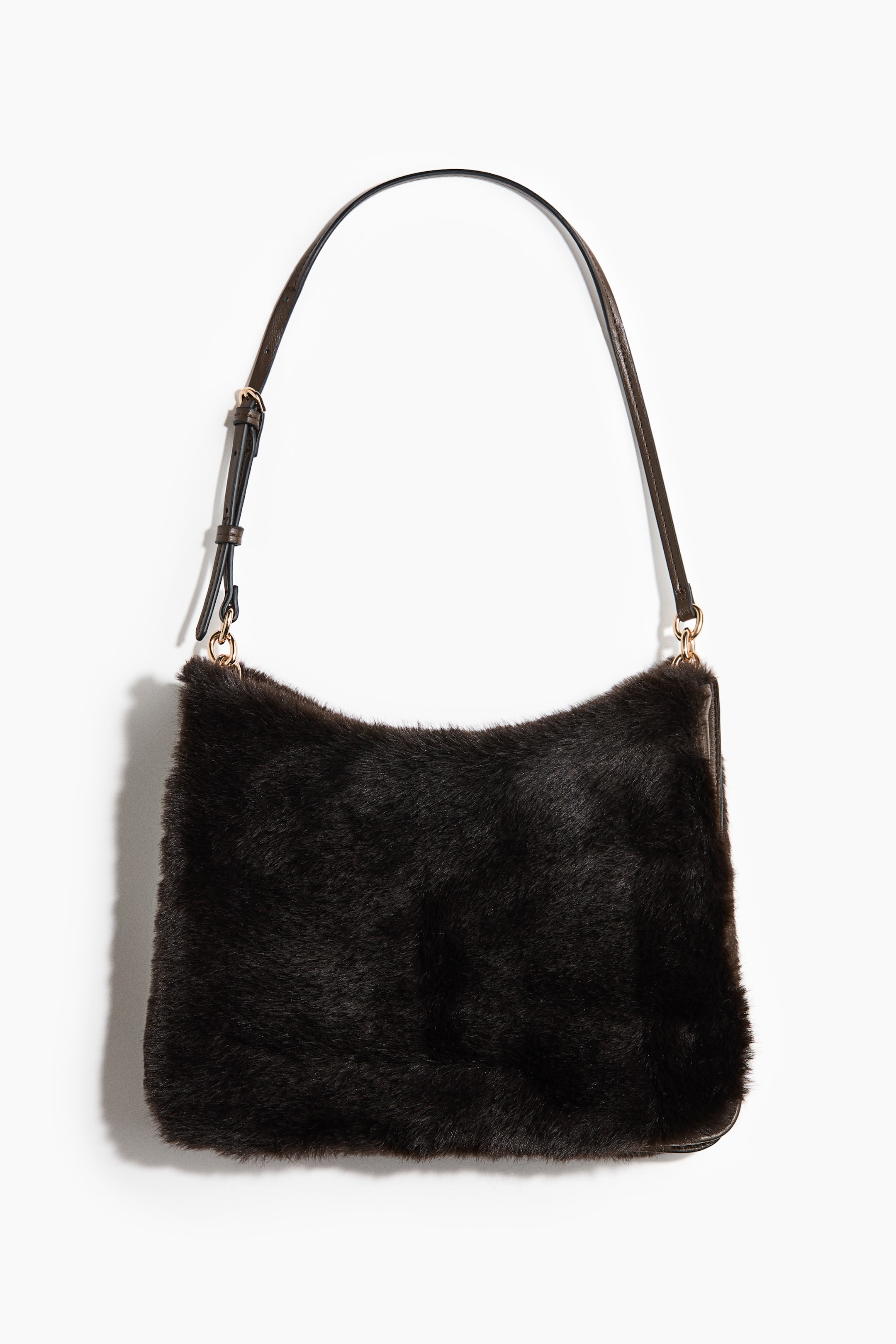 View larger image: A dark brown faux fur shoulder bag hangs facing forward, showcasing its soft, plush exterior and rectangular shape with a slightly curved top. It is suspended by a slim, adjustable dark brown shoulder strap connected with gold-tone metal hardware.