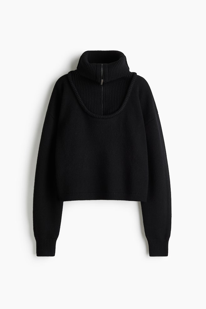 A black knit sweater is presenting a front view, featuring a layered design with a deep scoop-neck outer layer over a ribbed, high-collar half-zip insert. The sweater is showcasing a cropped silhouette with long sleeves, ribbed cuffs, and a ribbed hem. - 1