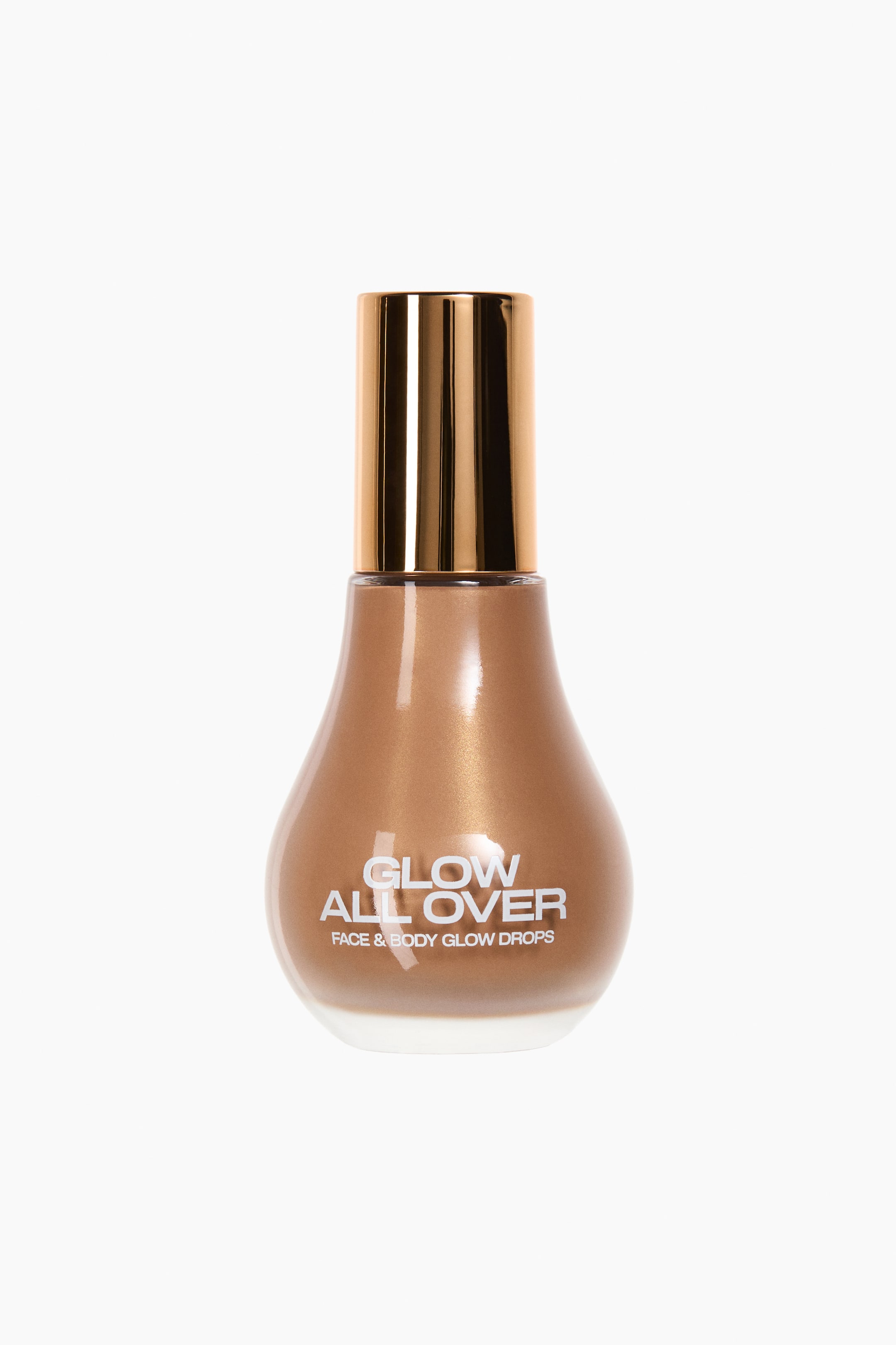 View larger image: A front-facing, clear, pear-shaped glass bottle contains a shimmering bronzed highlighter liquid. The bottle features a glossy gold cap and white text on its front reading "Glow All Over" and "Face & Body Glow Drops."
