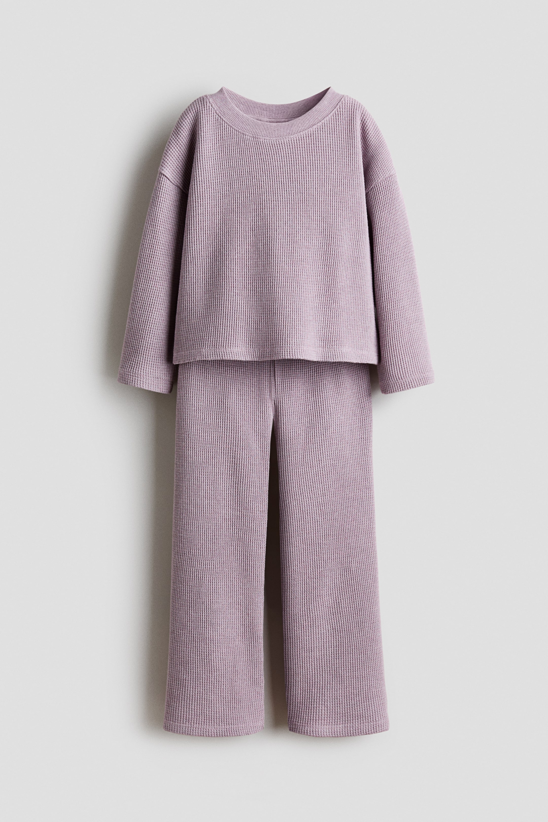 View larger image: A lilac waffle-knit two-piece set is displayed, shown from the front. The top features a crew neck, long sleeves with dropped shoulders, and a straight hem, while the wide-leg pants exhibit a relaxed fit and straight hems.
