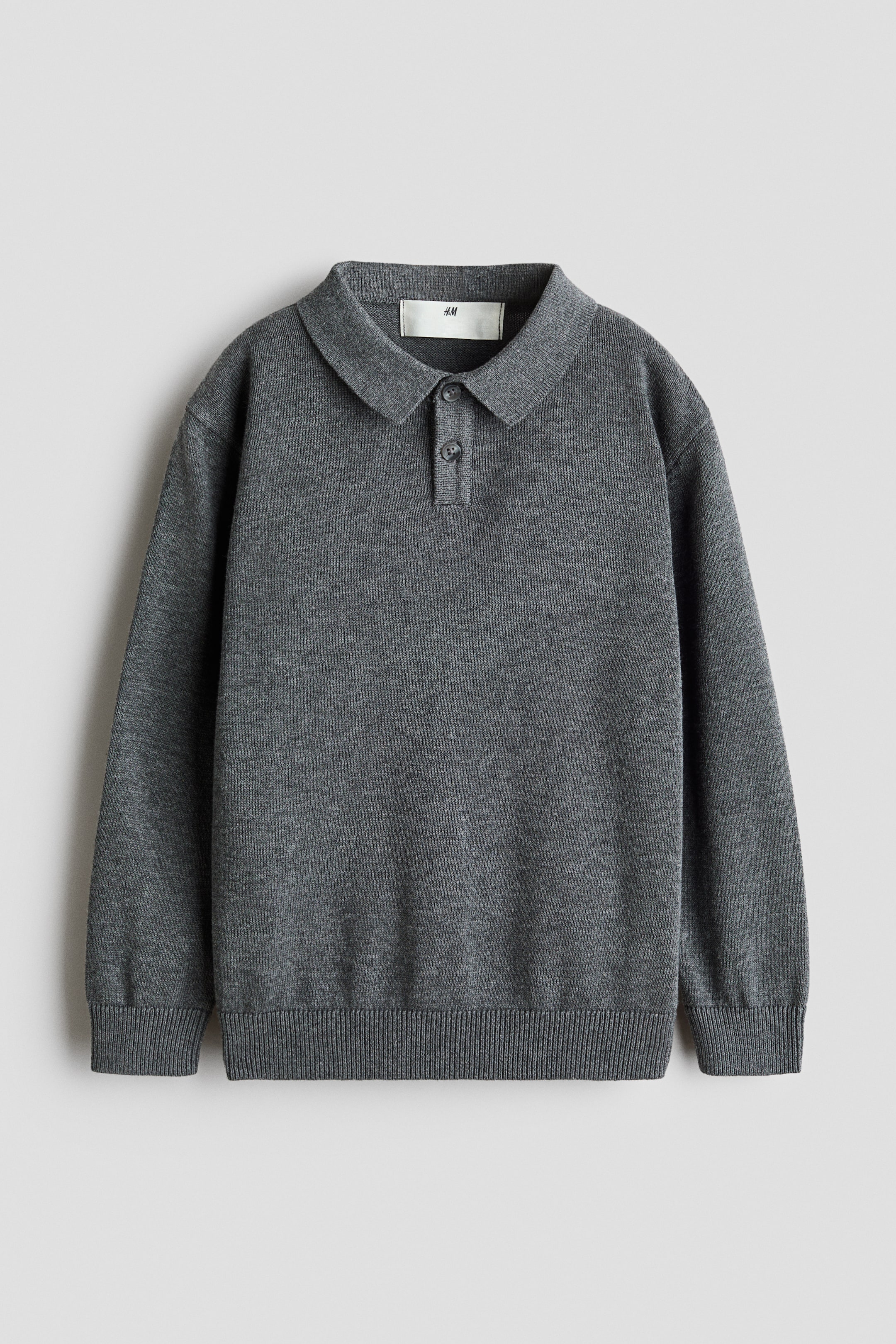 View larger image: A grey long-sleeved polo jumper is laid out flat, boasting a fine-knit texture, a classic collar, and a two-button placket. It features ribbed cuffs and a ribbed hem.