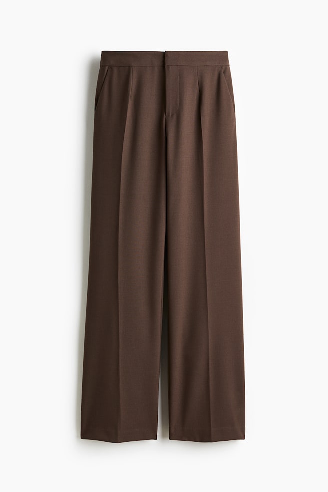 Brown tailored trousers in woven fabric are being displayed front, featuring a high waist that is secured with a zip fly, a concealed button, and hook-and-bar fasteners. Diagonal side pockets are visible, and the straight legs are showing prominent creases down the front and back. - 1