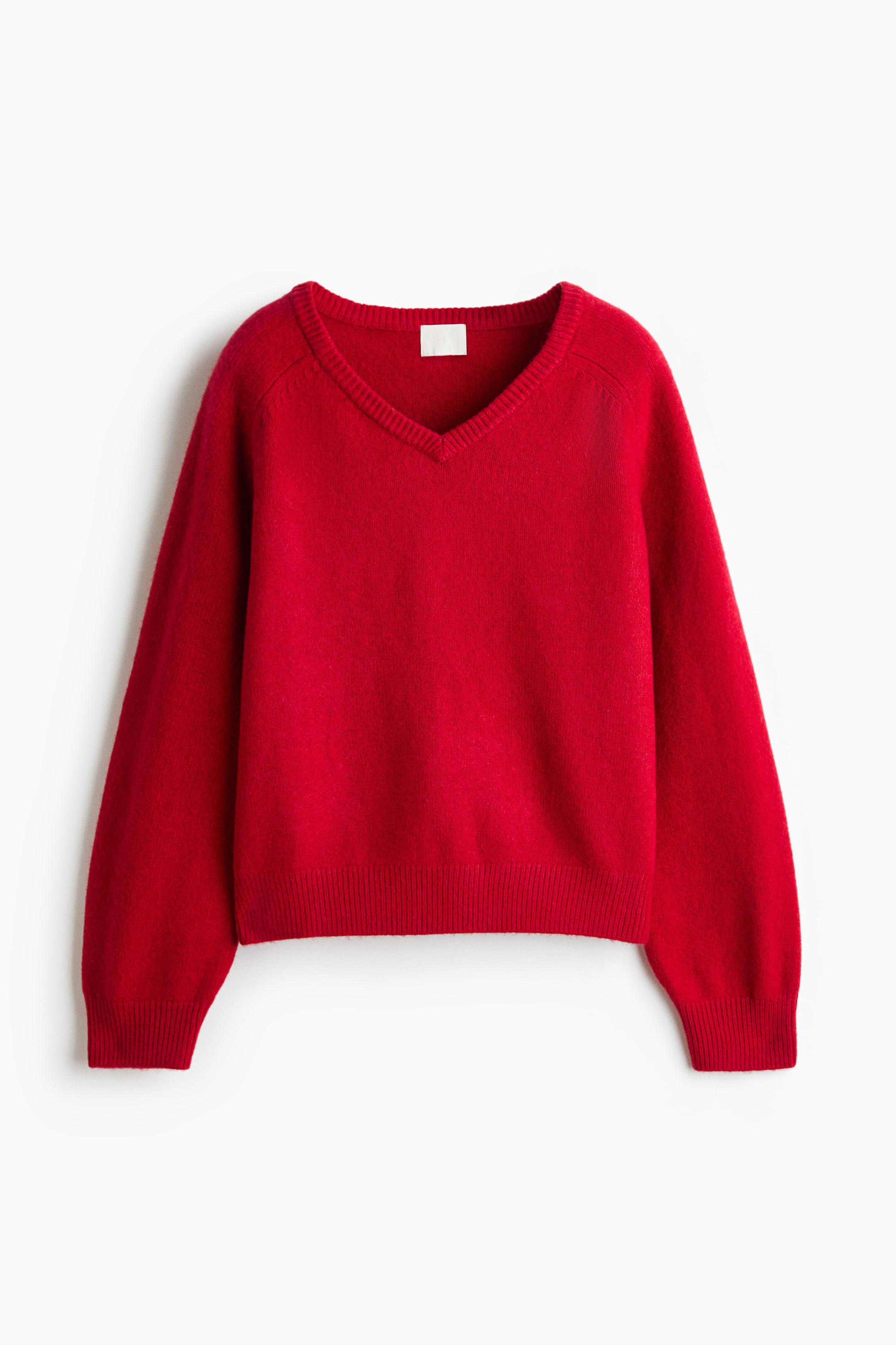 View larger image: A red V-neck sweater is shown from the front, featuring a ribbed V-neckline, long raglan sleeves, ribbed cuffs, and a ribbed hem.