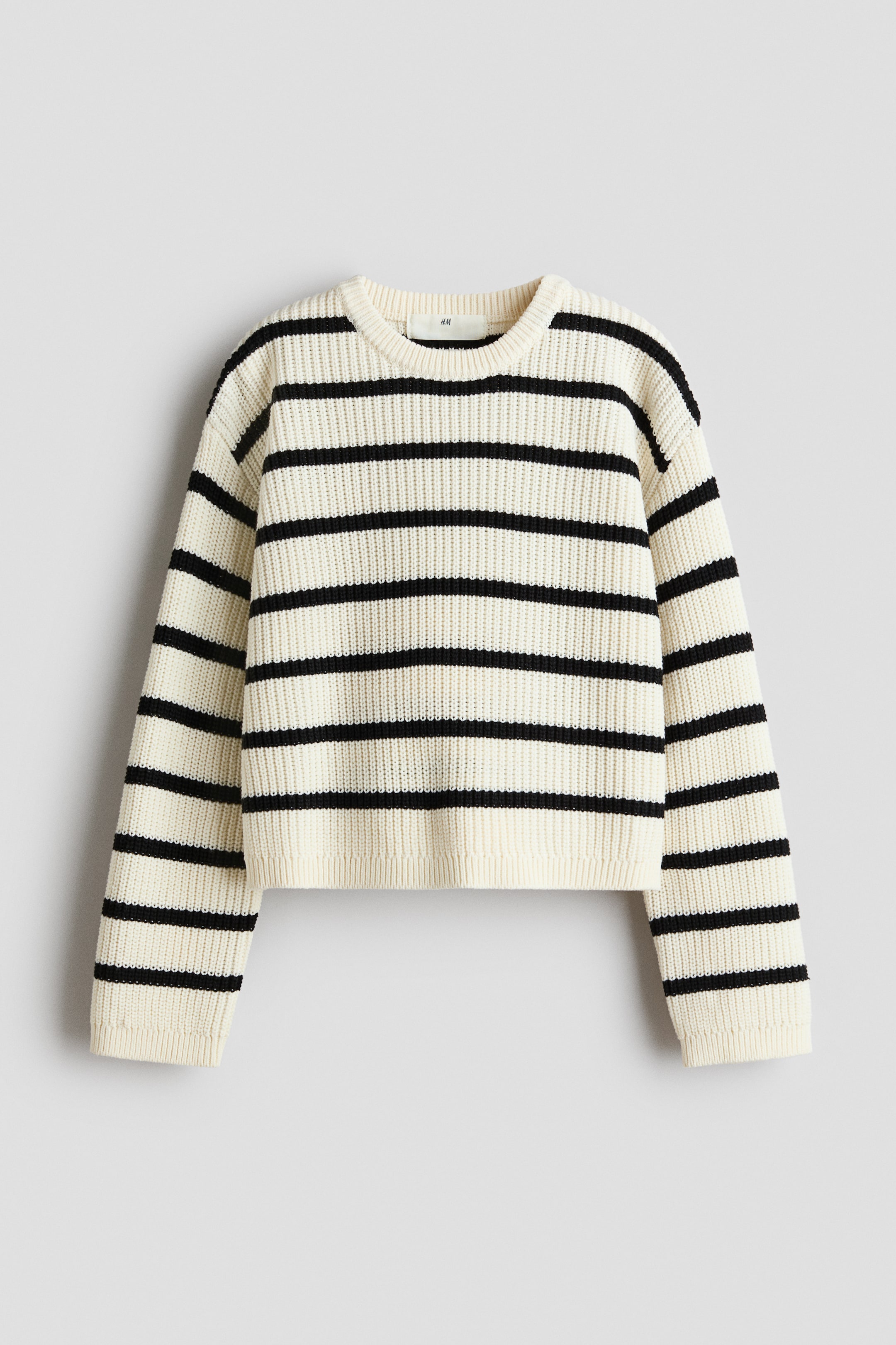 View larger image: The sweater showcases its front with a cream base adorned with broad black horizontal stripes. It boasts a chunky knit texture, a ribbed crew neck, ribbed cuffs, and a ribbed hem, all designed in a slightly cropped length.
