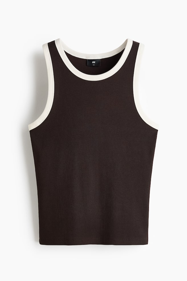 The deep brown tank top showcases a ribbed texture, accentuated with contrasting cream binding along the round neckline and armholes. A small H&M label is noticeable inside the back of the neckline, and the garment is displayed from the front view. - 1