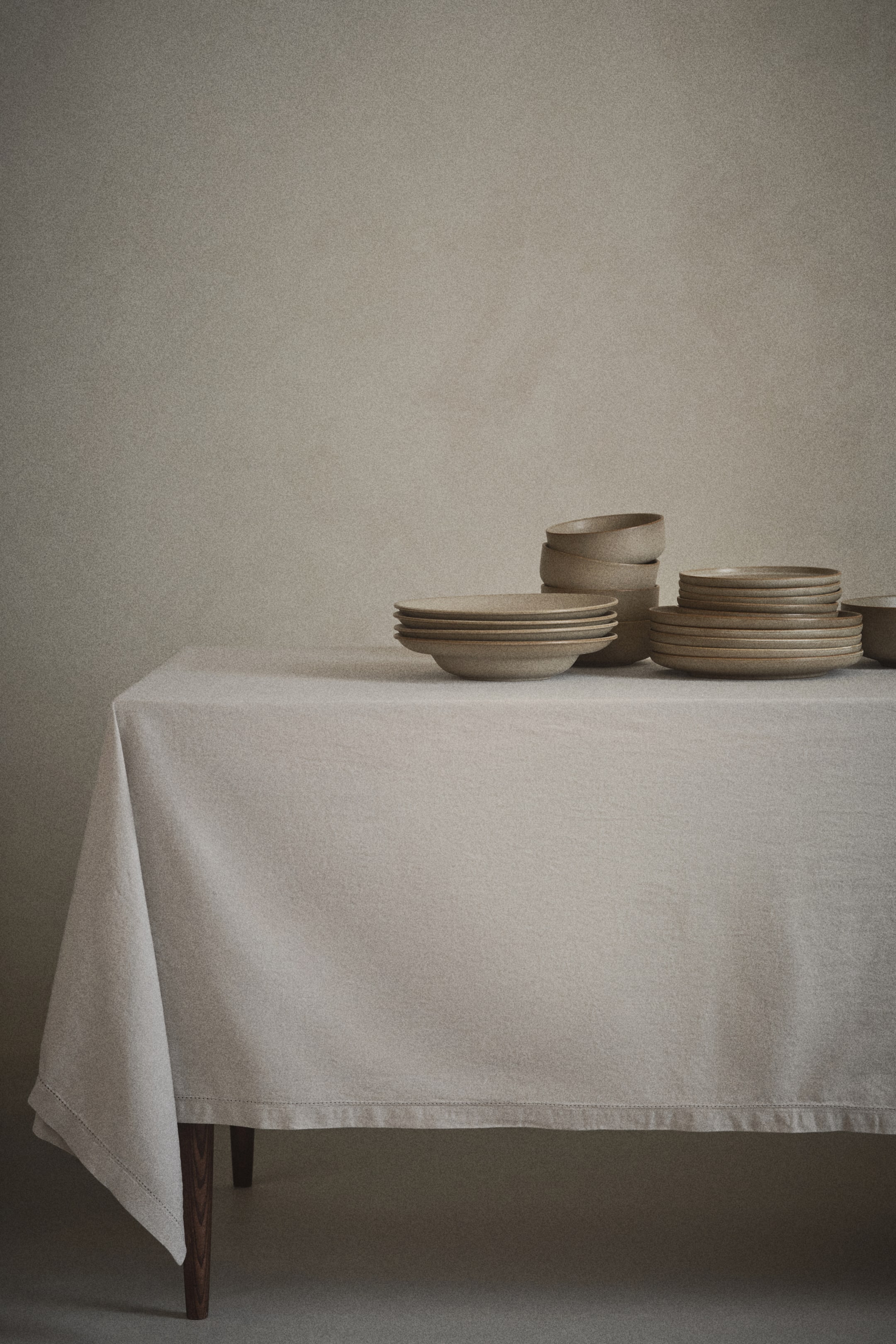 Agrandir l'image: Une nappe neutre légère en toile de coton, avec un nombre de fils de 240, recouvre une surface. Elle présente des détails de jours échelle le long de son ourlet de 2,5 cm.
