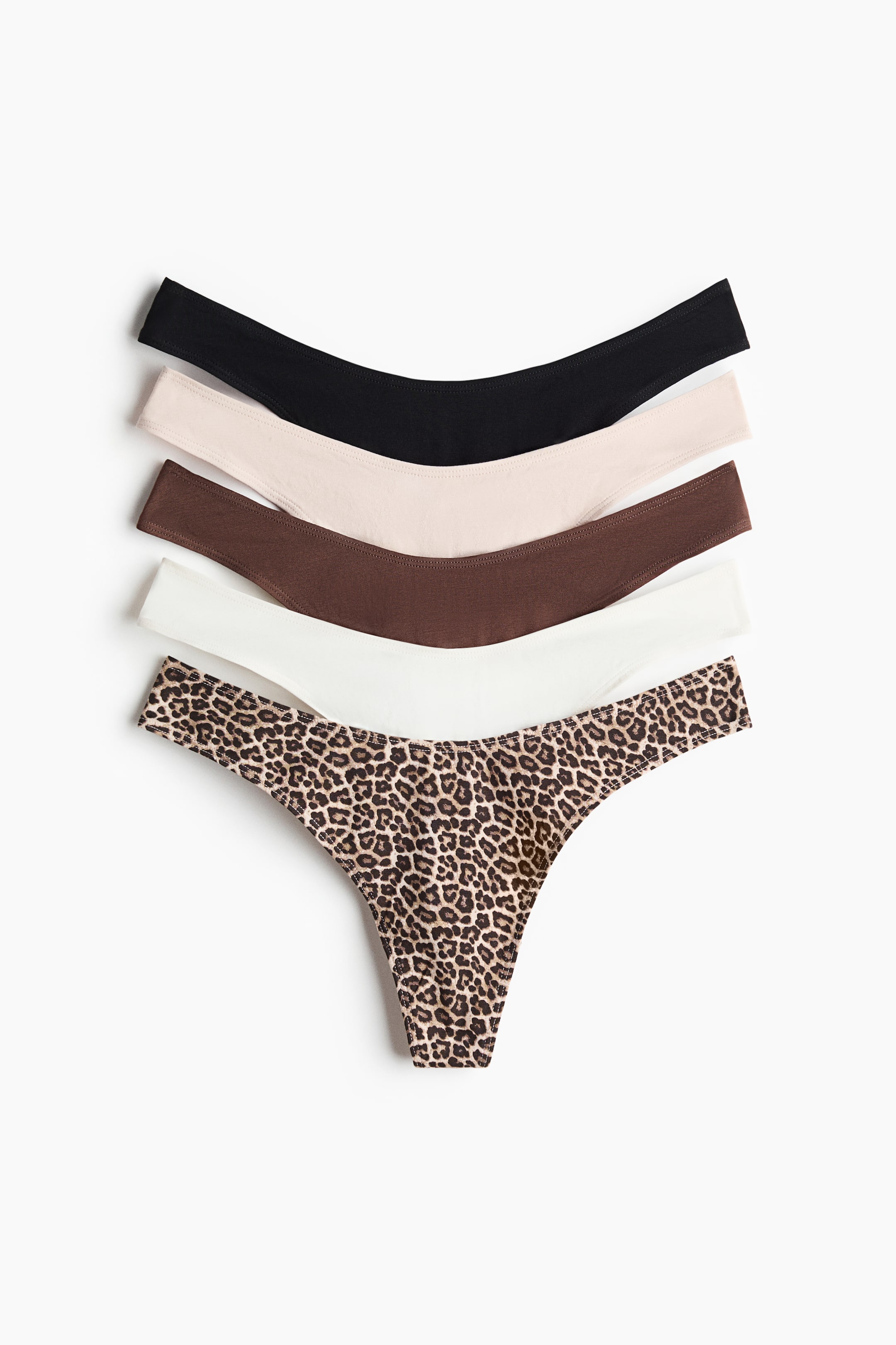 Voir une image plus grande: Cinq culottes tanga en jersey de coton sont empilées et disposées en éventail en diagonale, chacune présentant une taille basse en forme de V. Elles se déclinent en noir, beige clair, brun, blanc et imprimé léopard.