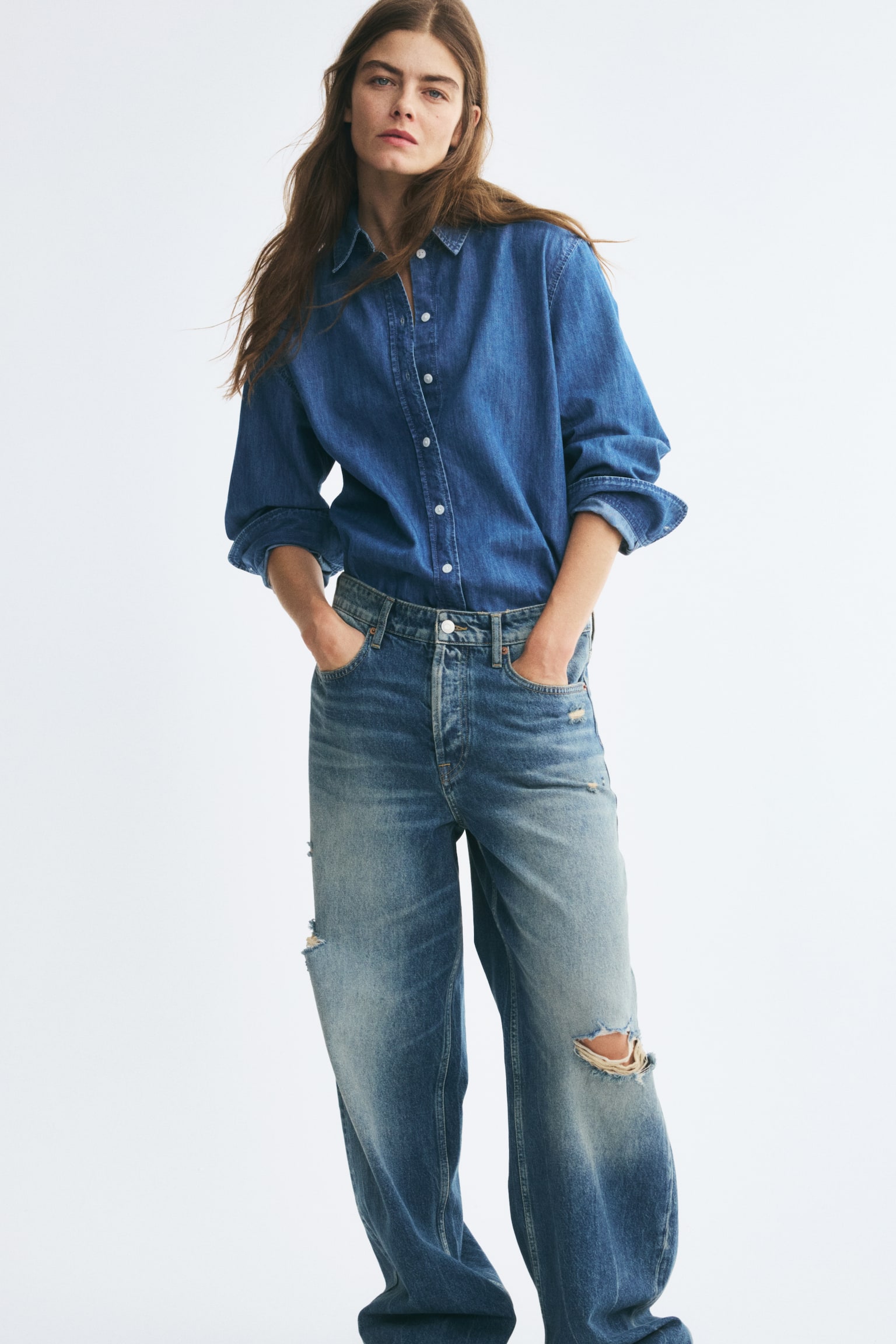 Ãnden gÃ¶sterilen, rahat kesimli mavi denim bir kot pantolon Ã§ifti, uyluklar ve dizlerde belirgin solma etkisiyle orta yÄ±kama gÃ¶rÃ¼nÃ¼mÃ¼nÃ¼ sergiliyor. Kot pantolon, her iki paÃ§ada yÄ±pranmÄ±Å yÄ±rtÄ±k detaylarÄ±, klasik beÅ cepli tasarÄ±m ve dÃ¼z paÃ§a silueti ile Ã¶ne Ã§Ä±kÄ±yor. - 1