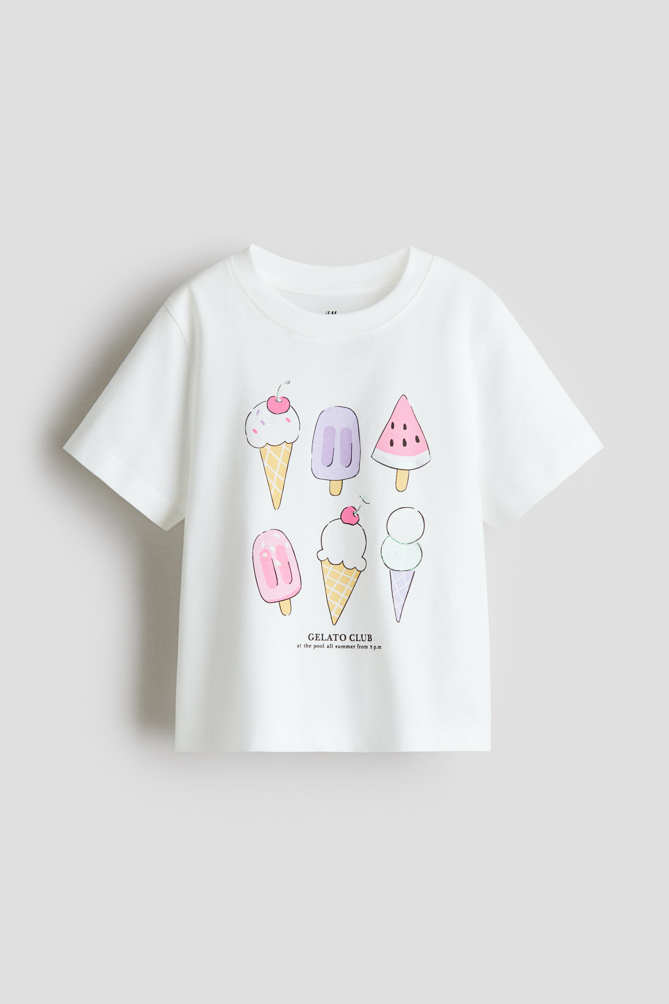 Xem ảnh lớn hơn: Một chiếc áo thun trắng làm từ chất liệu cotton jersey mềm mại, in hình, đang hướng mặt trước, có viền gân quanh cổ áo. Trên áo là hình ảnh đồ họa đầy màu sắc của sáu loại kem và kem que khác nhau, với dòng chữ "GELATO CLUB" được in phía dưới.