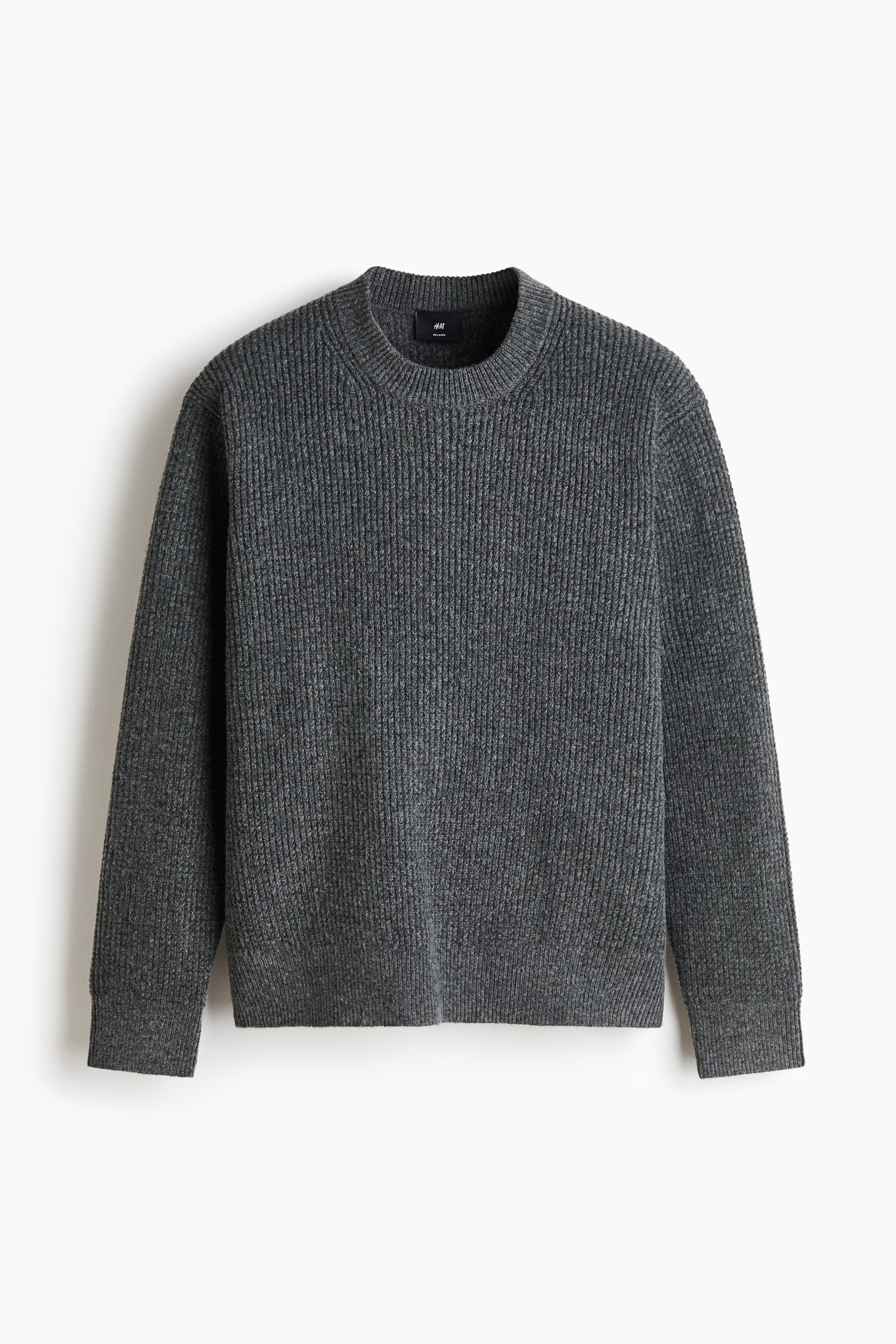 View larger image: A dark grey ribbed knit sweater is shown from the front. It features a crew neck, long sleeves with ribbed cuffs, and a ribbed hem. A small black H&M brand label is visible at the inner back neck.