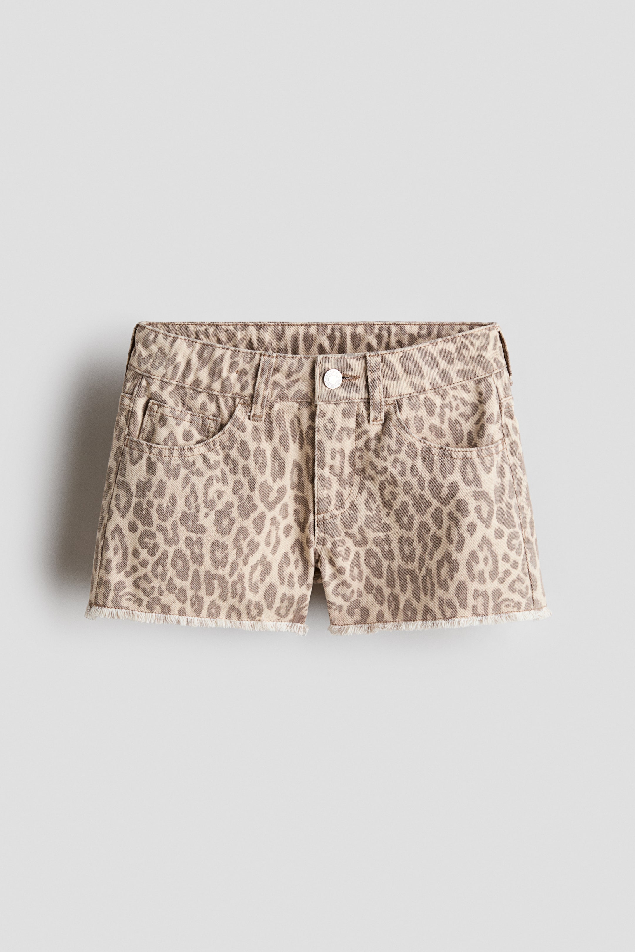 Ver imagen más grande: Pantalones cortos de mezclilla de algodón con 5 bolsillos, con un estampado de leopardo en beige y marrón, un ajuste relajado, cierre de cremallera con botón y dobladillos sin rematar, presentados desde el frente.