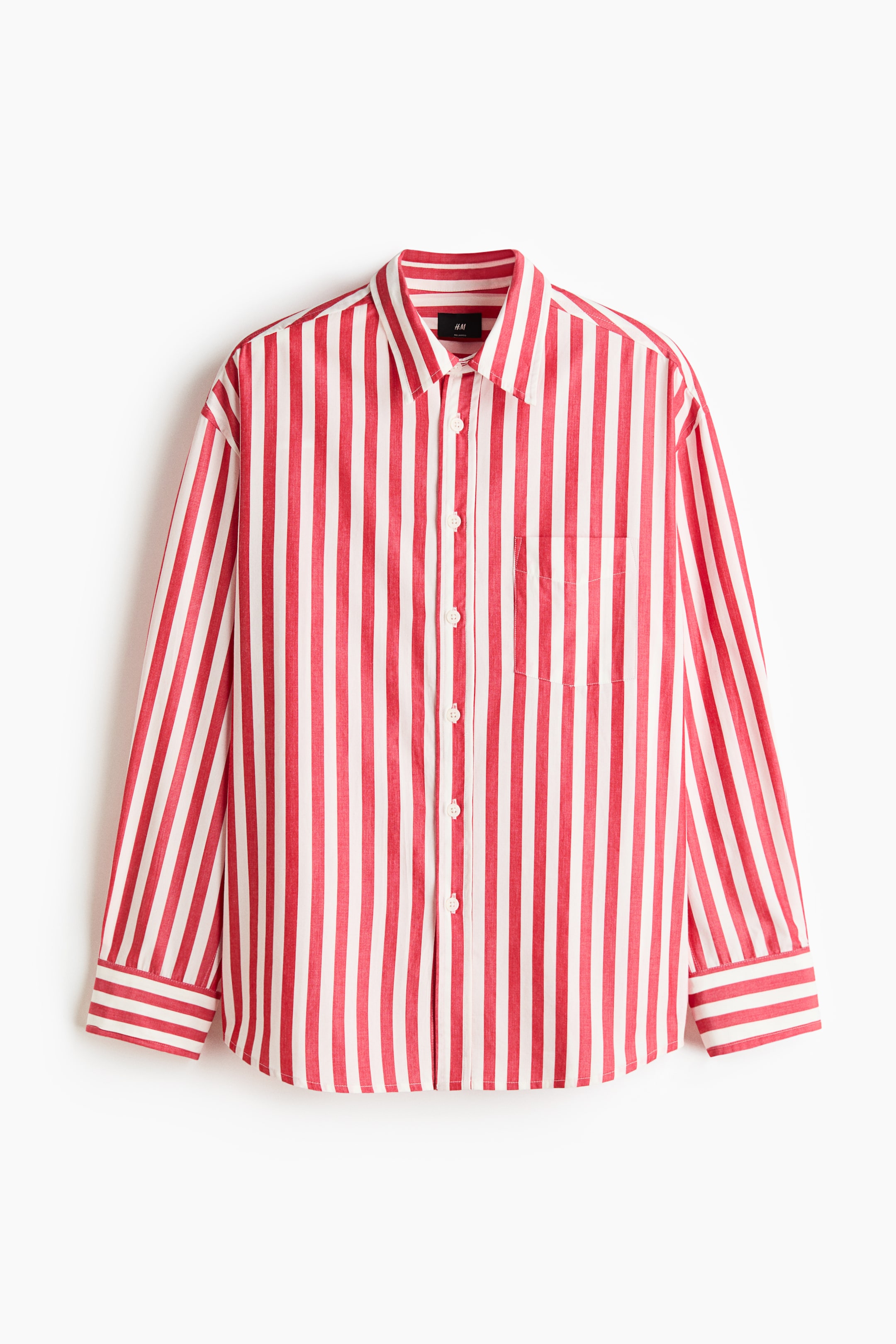 View larger image: This red and white vertical striped shirt is displayed front-facing, featuring a turn-down collar, a button-up front, an open chest pocket, long sleeves with buttoned cuffs, and a gently rounded hem, creating a loose silhouette.