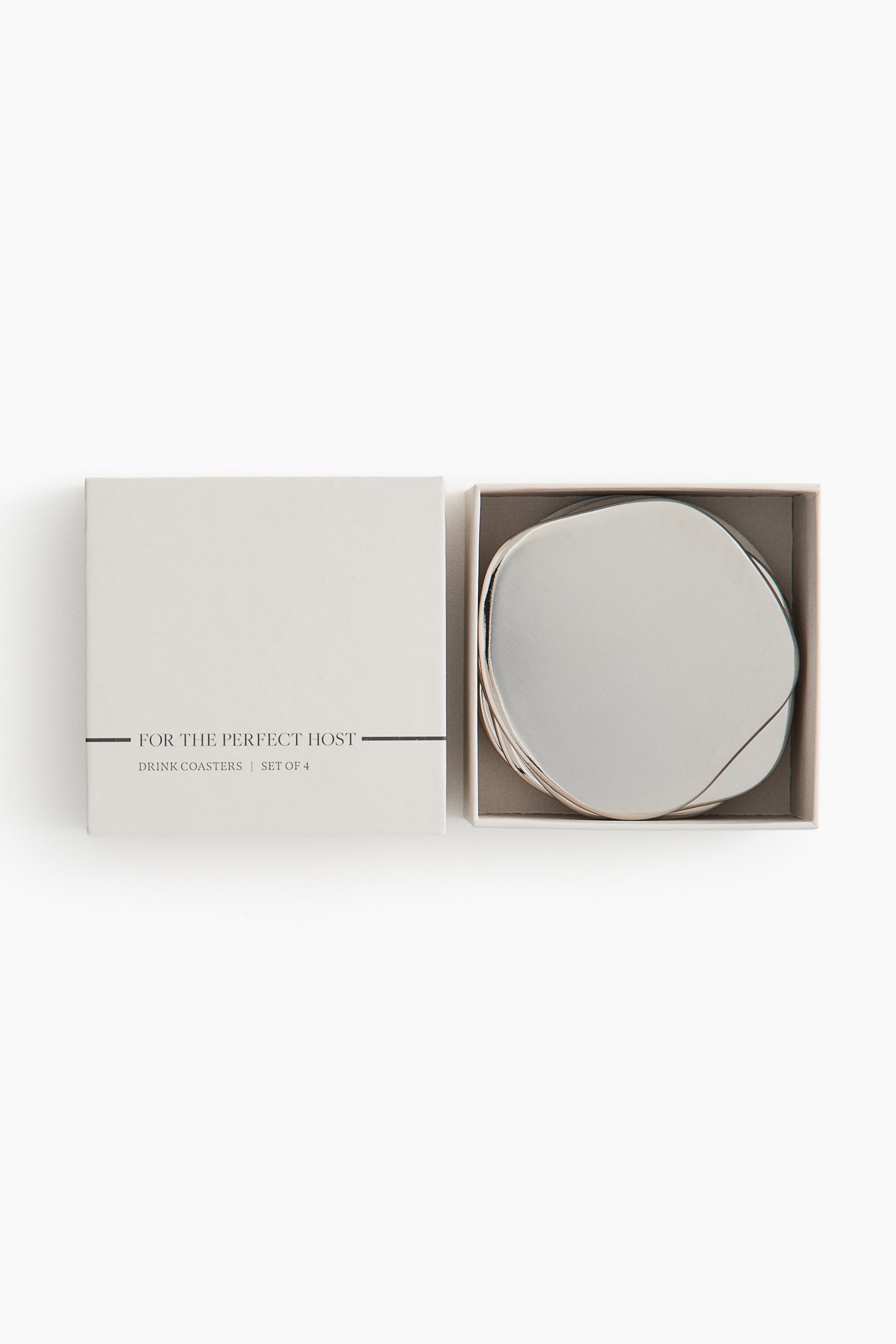 View larger image: A set of drink coasters is displayed in an open, light-colored square box. The box lid, positioned to the left, displays the text "FOR THE PERFECT HOST" and "DRINK COASTERS | SET OF 4." Four light-colored, irregularly shaped coasters are stacked inside the right side of the open box.