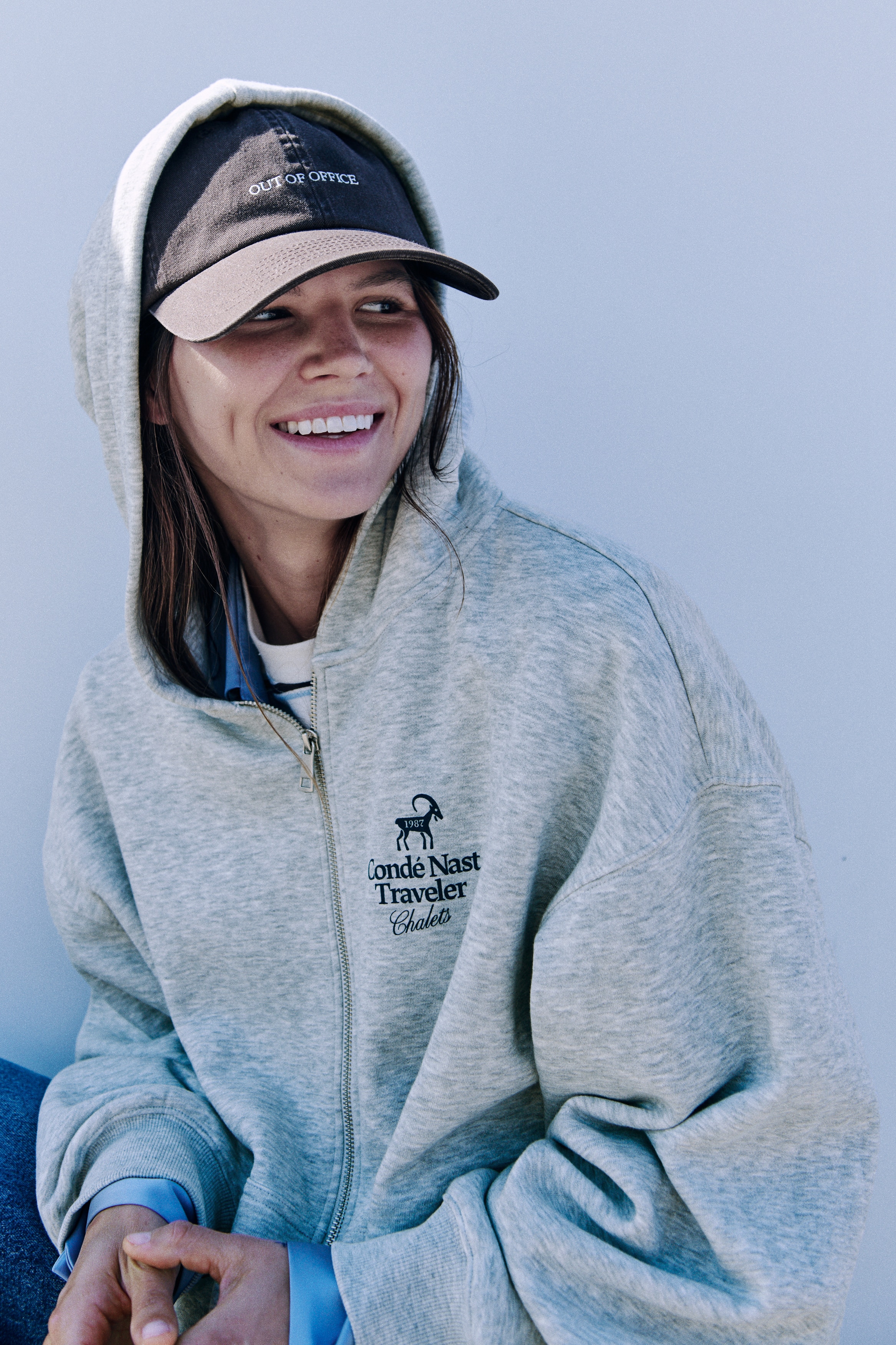 Má»t chiáº¿c Ã¡o hoodie kÃ©o khÃ³a mÃ u xÃ¡m nháº¡t ÄÆ°á»£c chá»¥p tá»« phÃ­a trÆ°á»c, cÃ³ khÃ³a kÃ©o kim loáº¡i dÃ i toÃ n thÃ¢n, tÃºi kangaroo chia ÄÃ´i vÃ  bo tay cÃ¹ng gáº¥u Ã¡o dá»t gÃ¢n. á» ngá»±c trÃ¡i cÃ³ hiá»n thá» má»t logo mÃ u xanh nhá» ghi "Condï¿½ Nast Traveler Chalets" bÃªn dÆ°á»i hÃ¬nh minh há»a má»t con dÃª nÃºi.