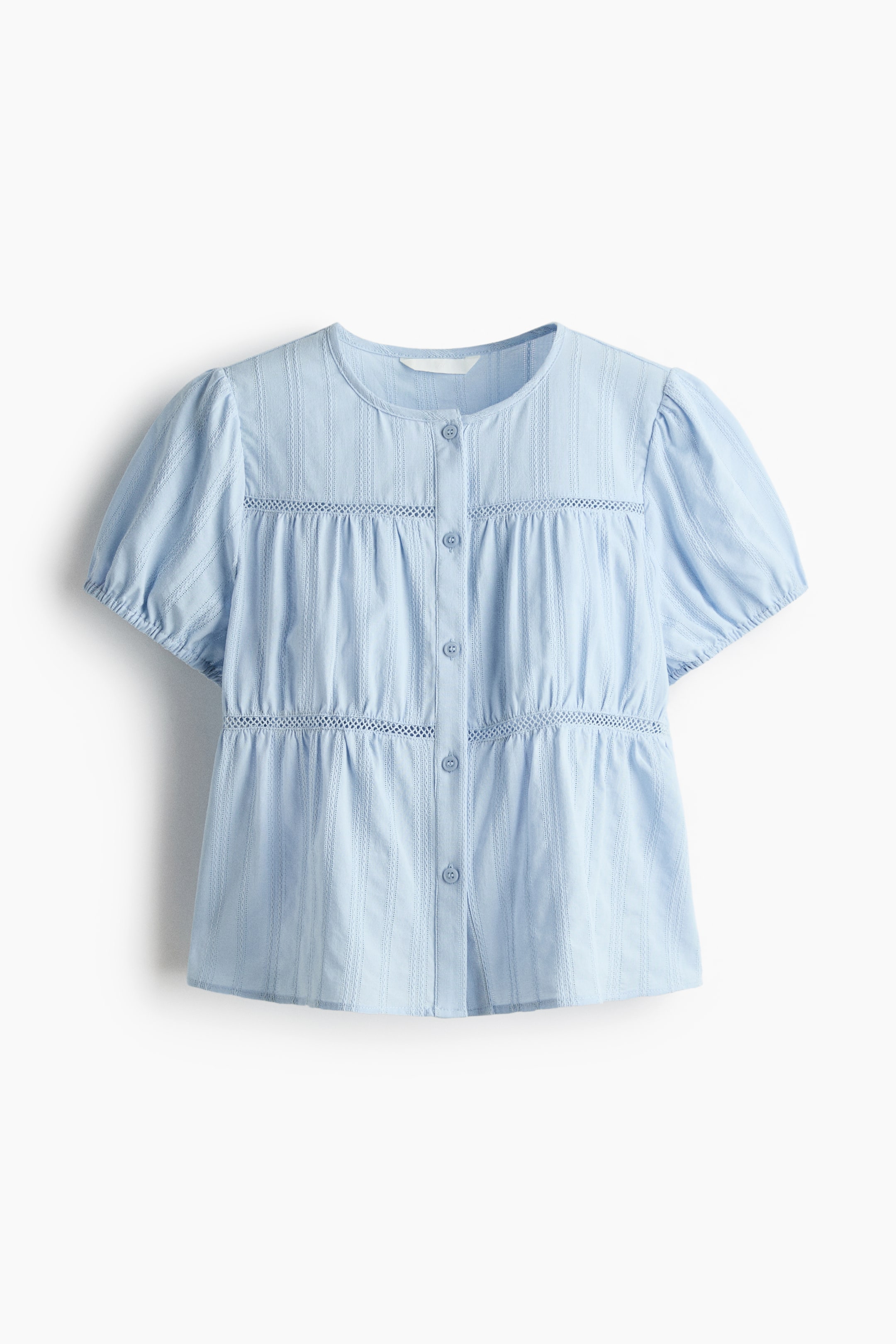 Xem ảnh lớn hơn: Một chiếc áo blouse màu xanh nhạt đang hướng về phía trước, có cổ tròn và hàng cúc trước đầy đủ. Nó có tay áo ngắn phồng với cổ tay co giãn và họa tiết sọc nổi, được nhấn nhá bằng các dải ren openwork ngang qua ngực và eo, với phần xếp nếp tạo nên dáng peplum.