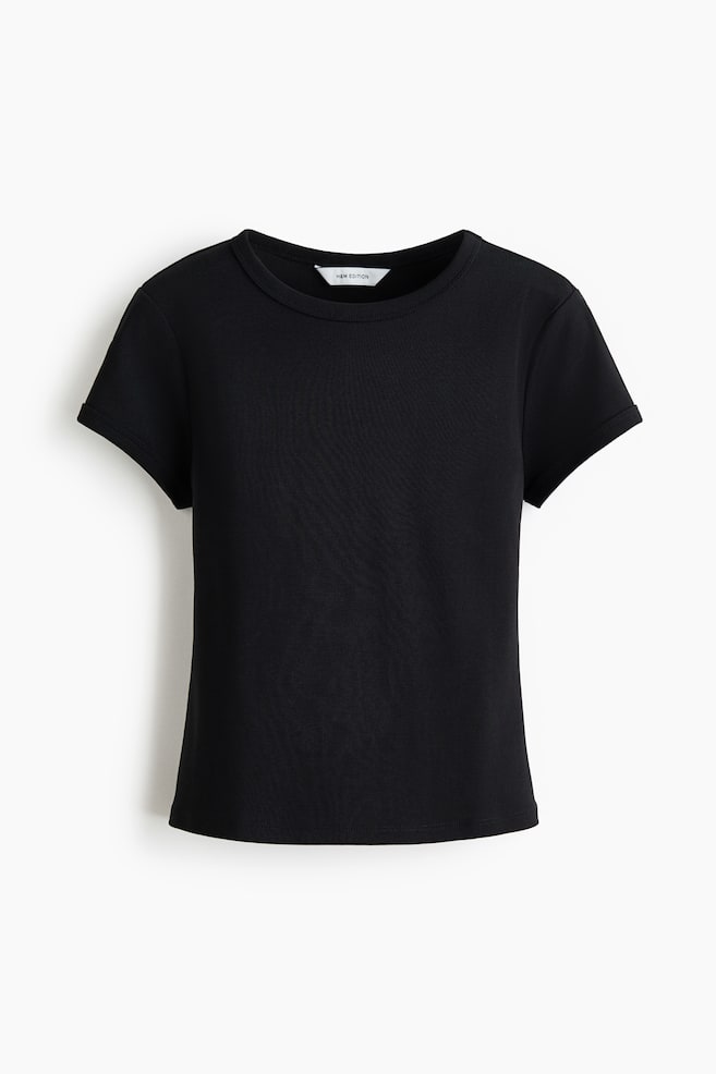 A black t-shirt is showcasing its front view, highlighting a ribbed crew neck and short sleeves. A white "H&M EDITION" tag is visible on the inside back collar. - 1