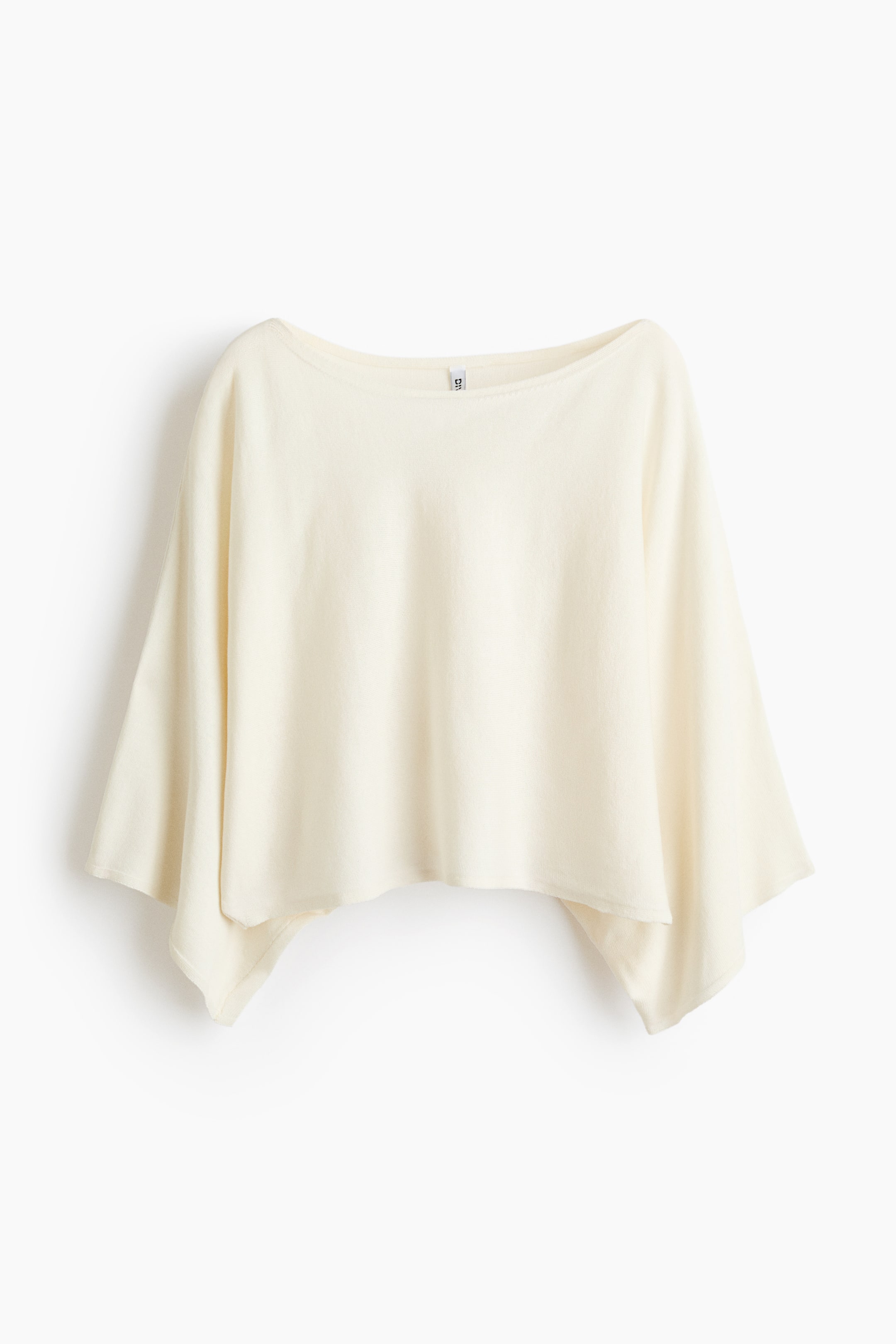 Größeres Bild anzeigen: Ein cremefarbenes Poncho-Top mit Bootsausschnitt und weiten Dolman-Ärmeln. Die Vorderseite zeigt einen asymmetrischen Saum, der für einen entspannten Fall sorgt.