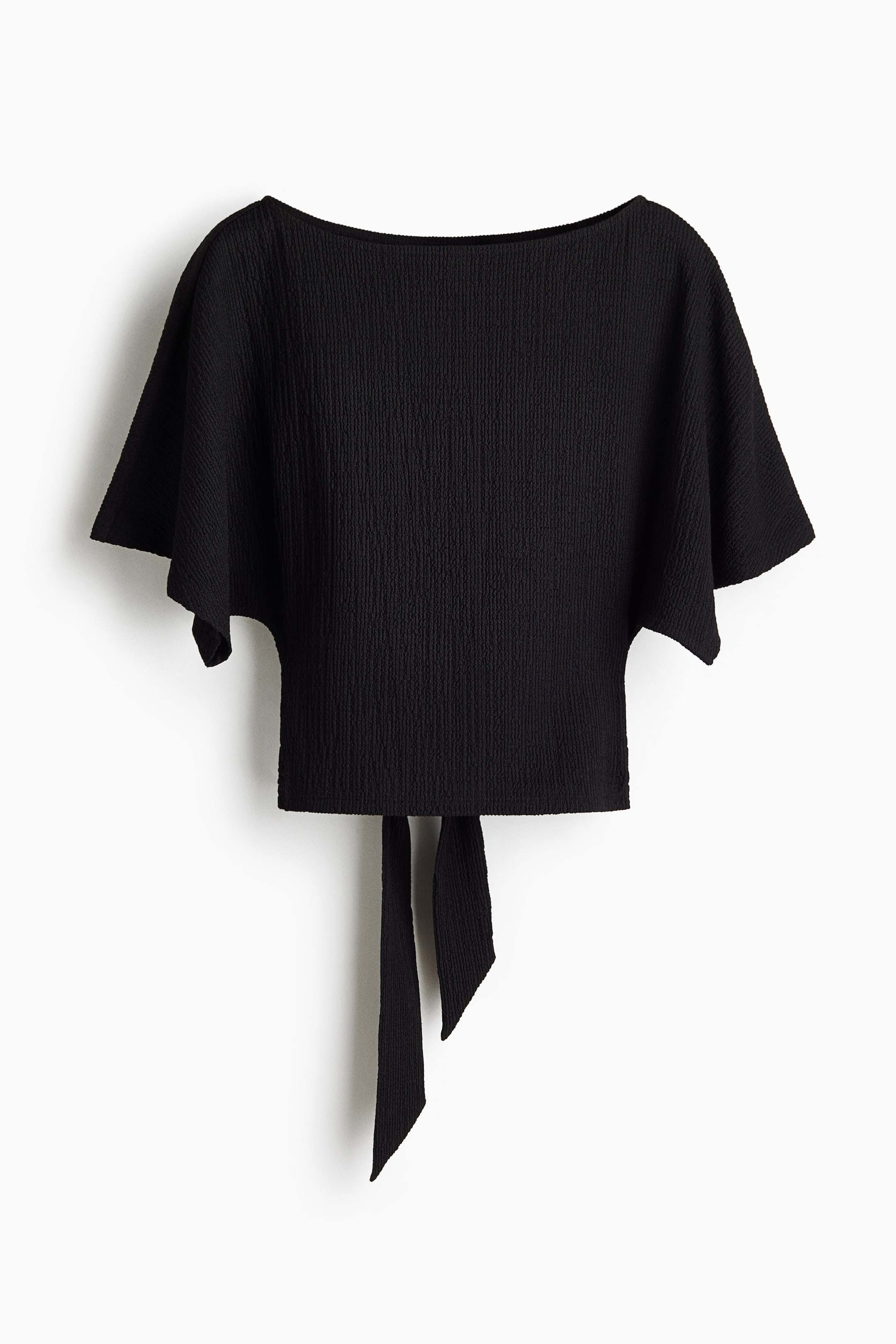 View larger image: This black top showcases a crinkled texture, a broad boat neckline, and short dolman sleeves. At the back, two ties extend from the bottom hem.