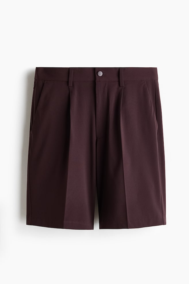 Dunkelburgunder Shorts präsentieren eine Vorderansicht, mit einem flachen Bund, einem einzelnen Knopfverschluss und Gürtelschlaufen. Sie zeigen vordere Falten an jedem Bein und Seitentaschen und reichen bis zu einer Länge oberhalb des Knies. - 1
