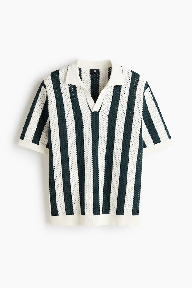 A short-sleeved knitted polo shirt featuring an open-knit texture with vertical dark green and off-white stripes. It presents a pointed collar, a V-neck opening, and ribbed cuffs and hem. - 1