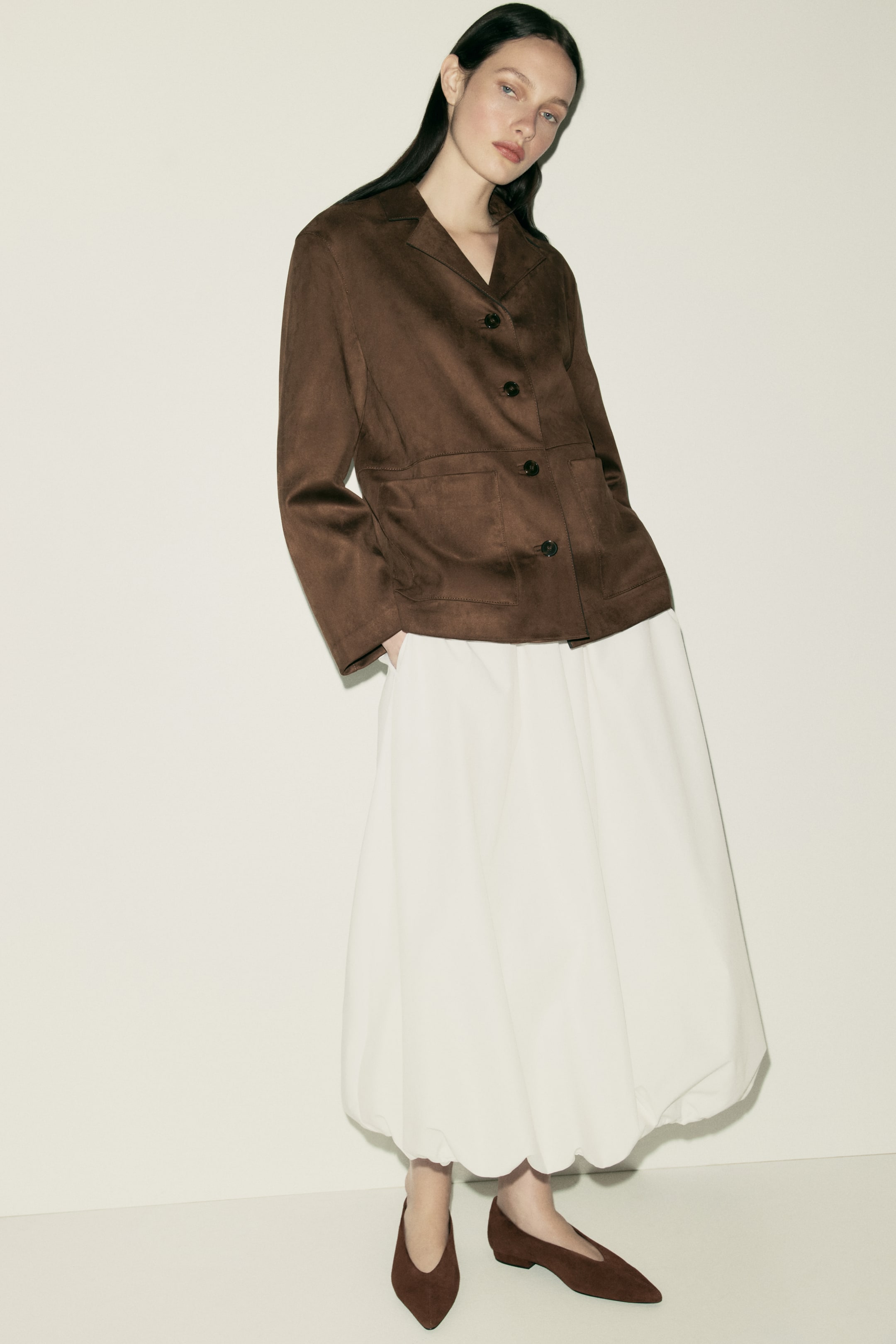 Προβολή μεγαλύτερης εικόνας: Ένα καφέ σακάκι, εμφανίζεται σε ύφασμα σουέτ, διαθέτει πέτα με εγκοπές, κλείσιμο με τέσσερα κουμπιά μπροστά και δύο τσέπες τύπου patch. Προσφέρει μια χαλαρή εφαρμογή ενώ κοιτάζει ελαφρώς προς τα αριστερά.