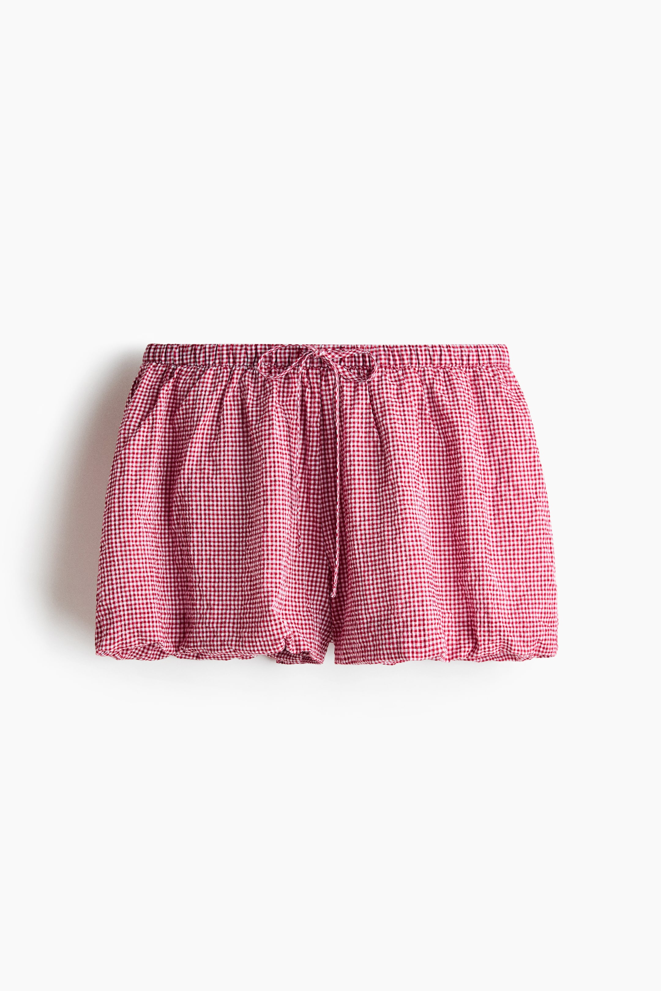 View larger image: Lined beach shorts in a red and white gingham cotton weave feature an elasticated, drawstring waist tied at the front. Bubble hems create a puffy silhouette.